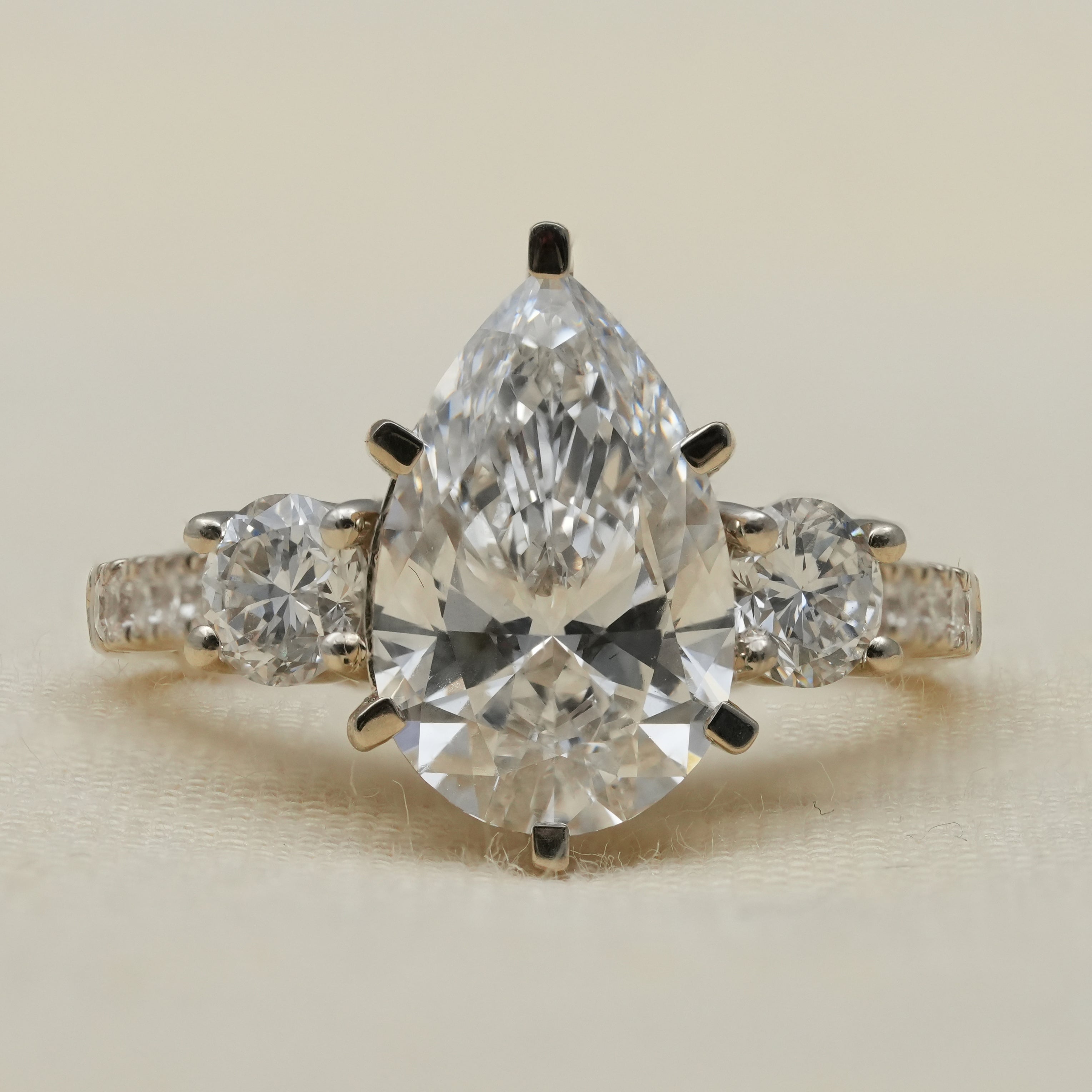 Pear three stone lab grown diamond ring with round side stones