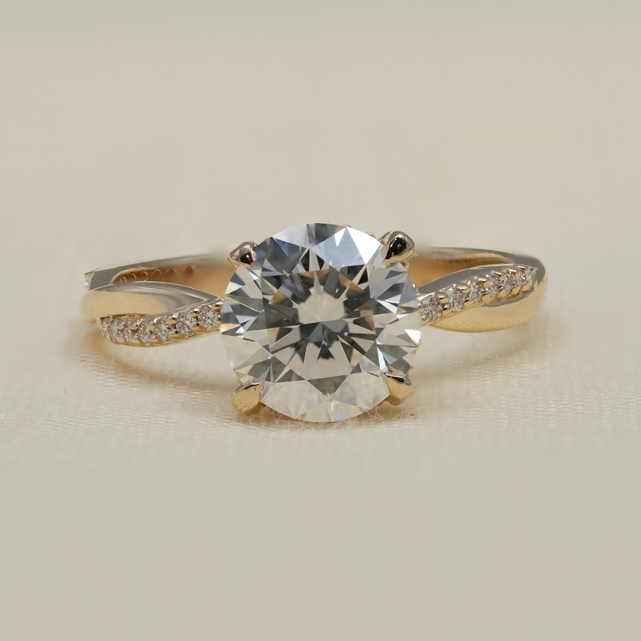 Round lab grown diamond engagement ring with twisted yellow gold band