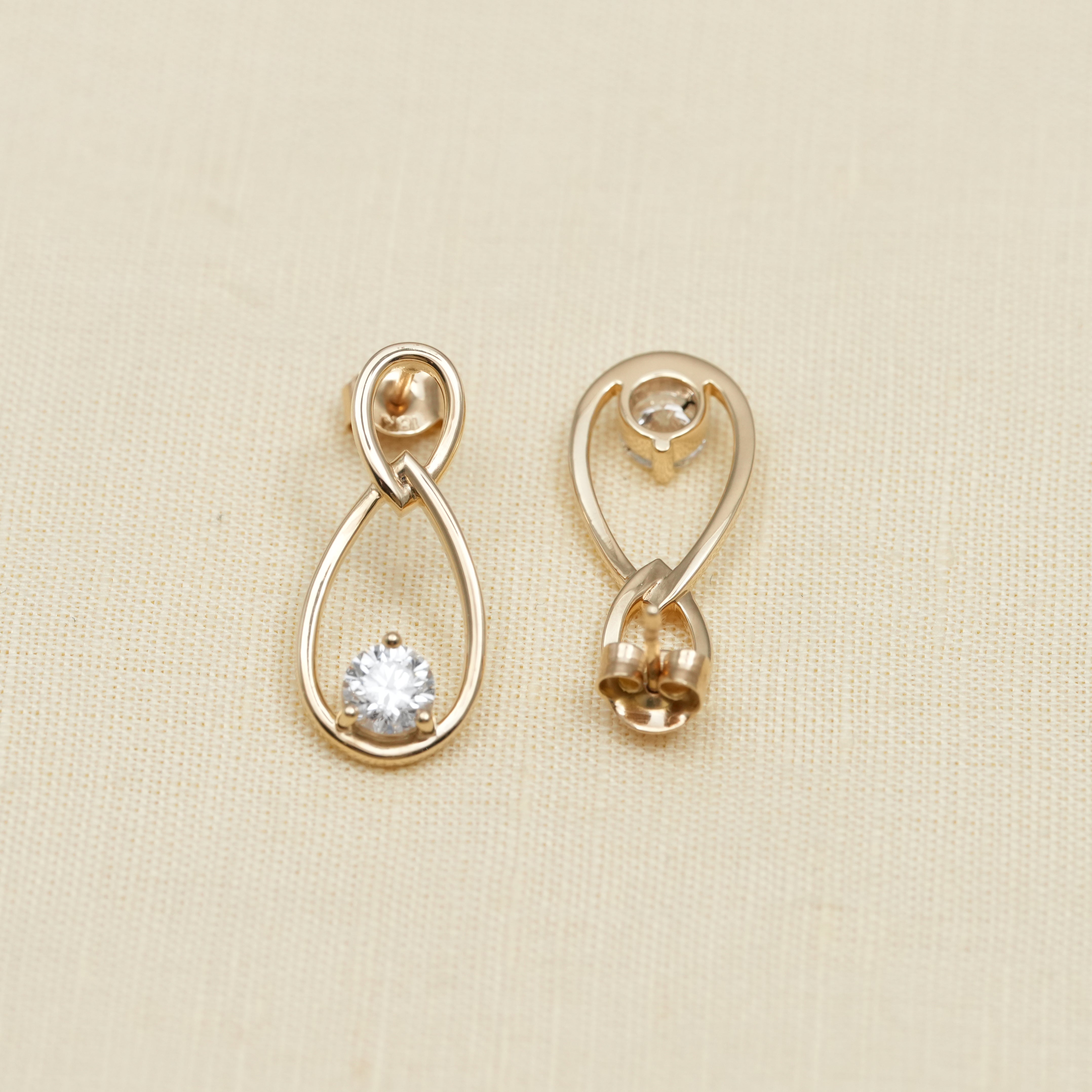 Minimal gold teardrop earrings with dangling round diamond detail