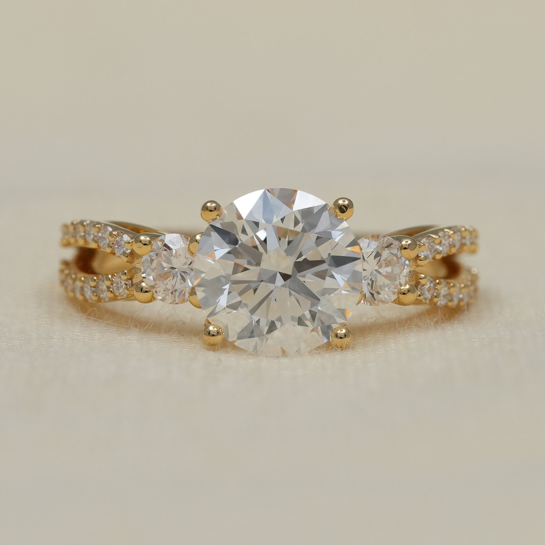 Round lab grown diamond three stone engagement ring with split shank