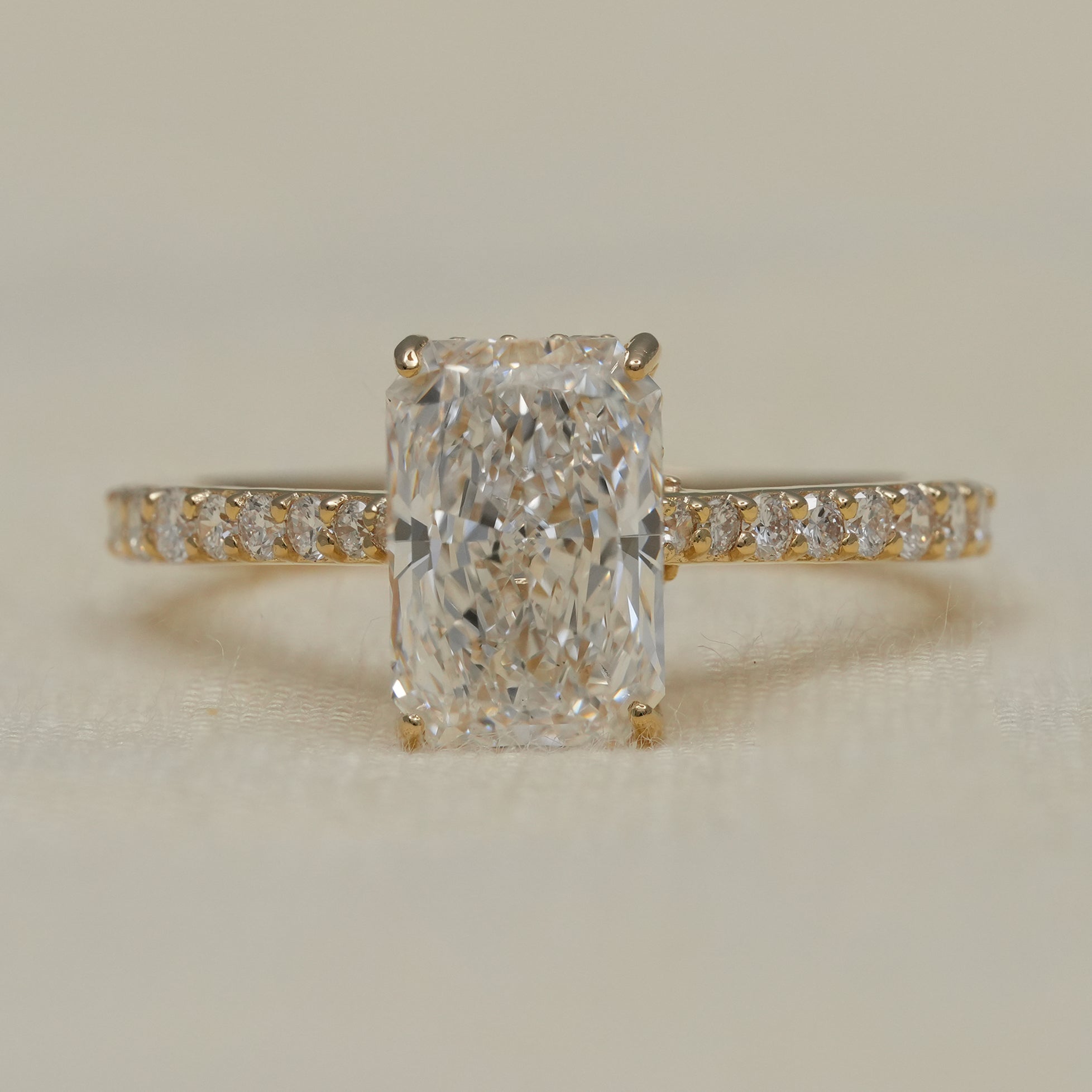 Radiant cut lab grown diamond engagement ring with pavé yellow gold band