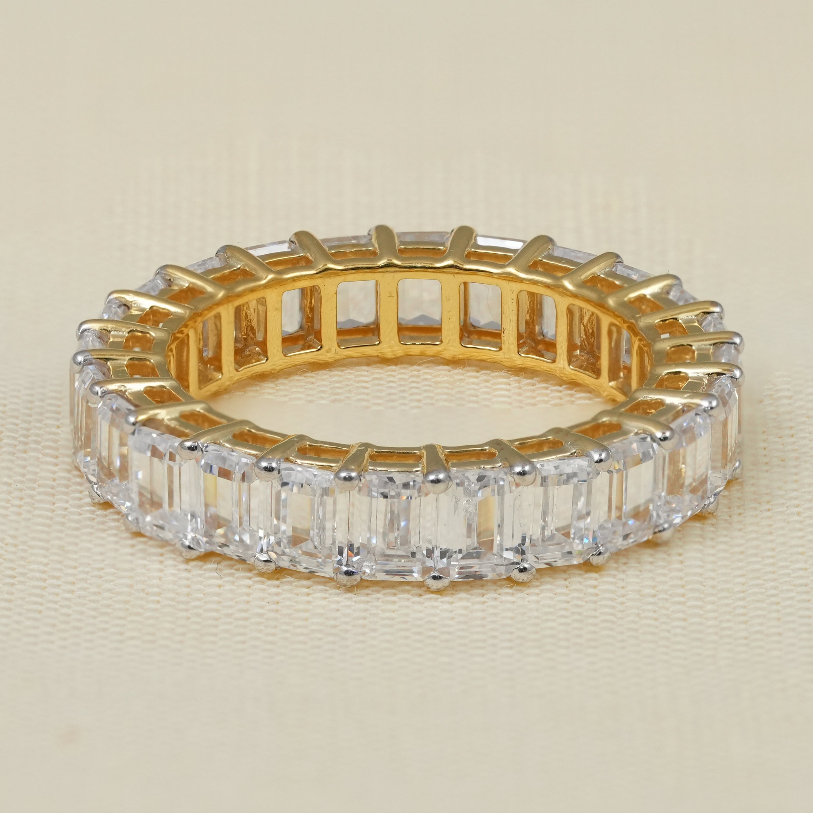 Emerald cut lab grown diamond eternity band in polished yellow gold