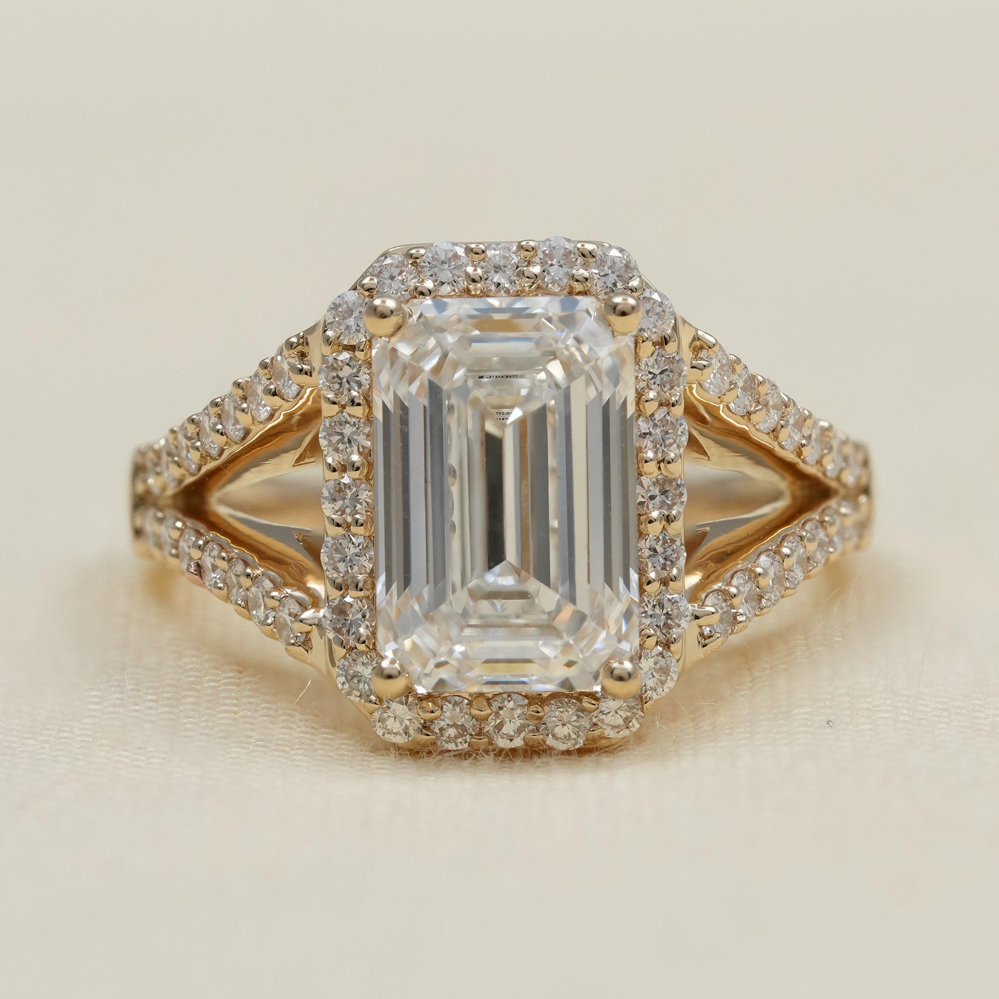 Emerald cut lab grown diamond halo engagement ring in yellow gold