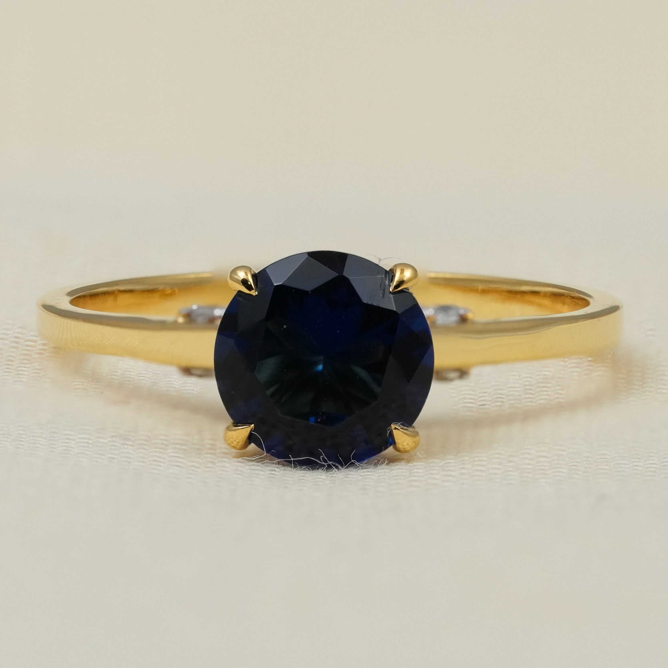 Round blue sapphire solitaire ring set in polished yellow gold