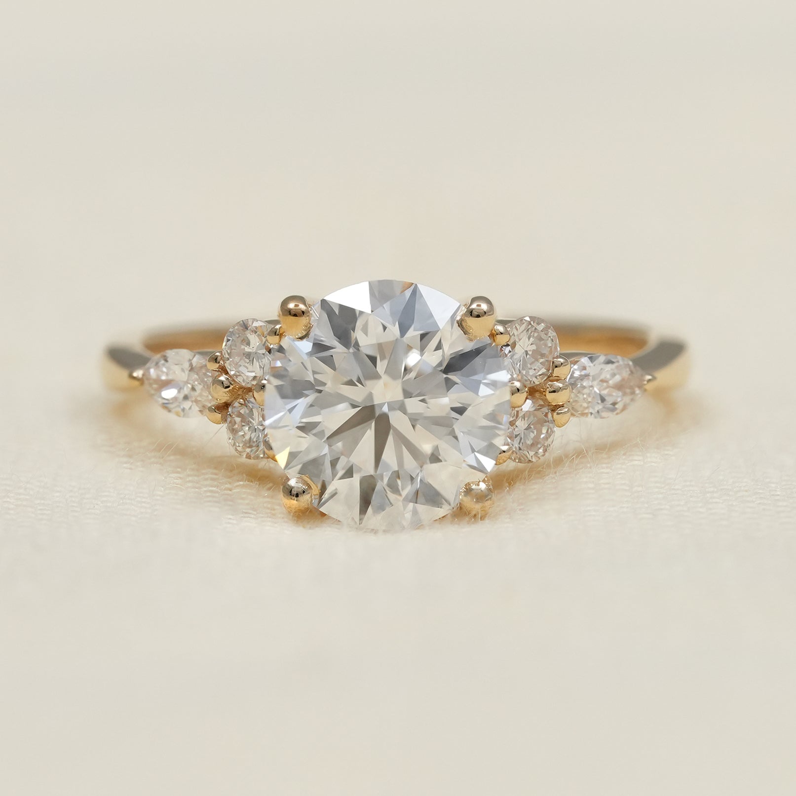 Round lab grown diamond engagement ring with marquise side stones