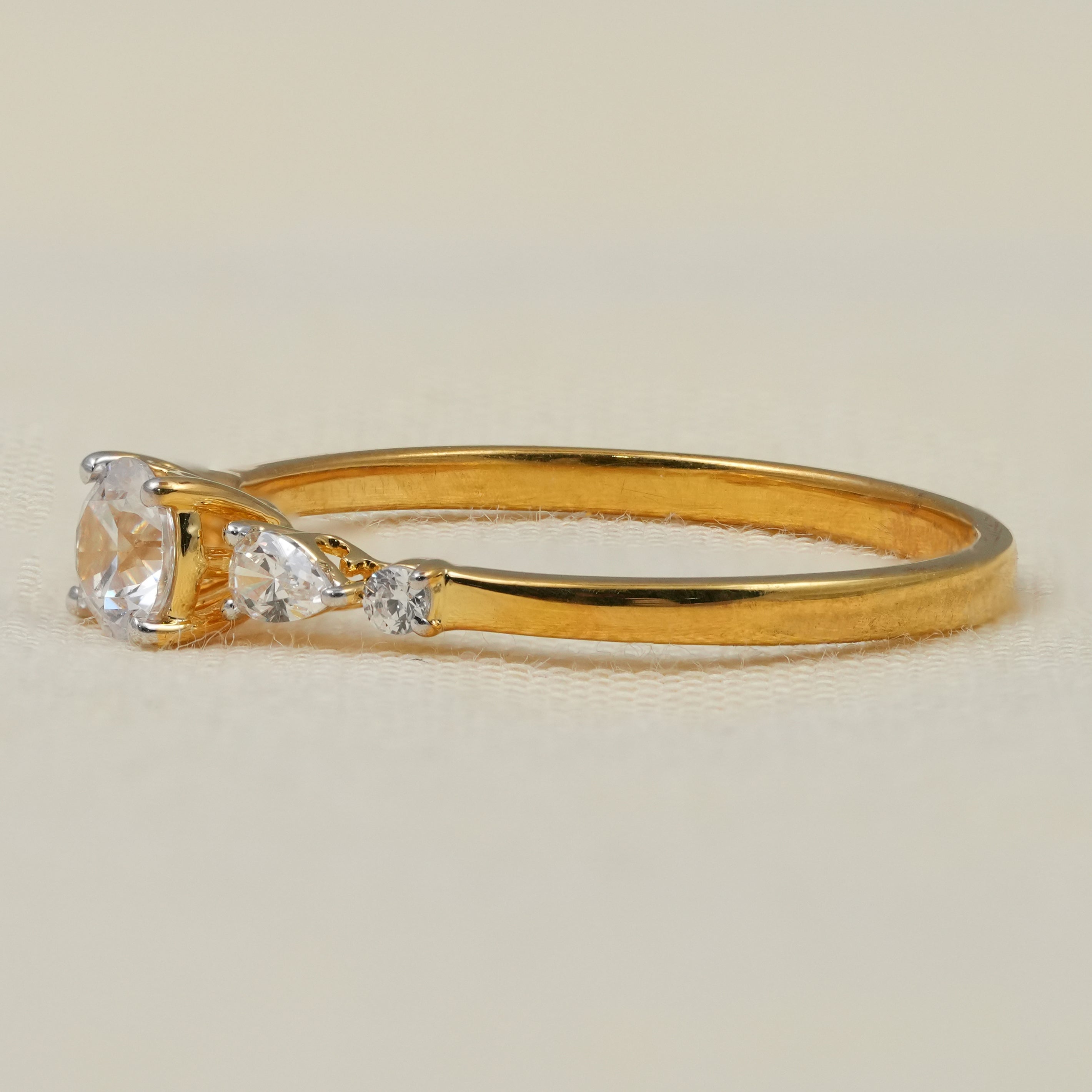 Minimalist yellow gold ring featuring round lab grown diamond with tapered pear accents
