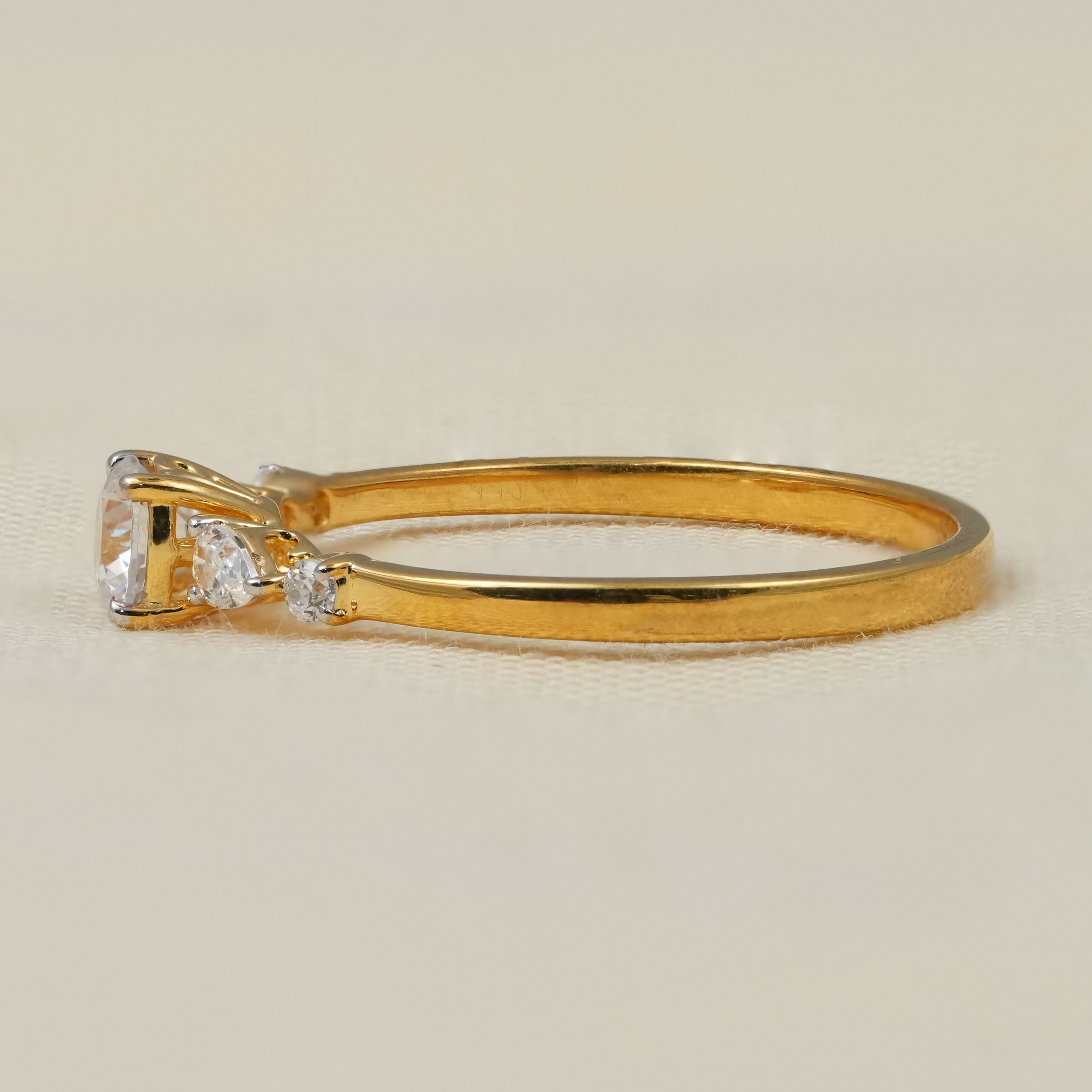 Elegant round lab grown diamond solitaire with pear side stones on slim gold band