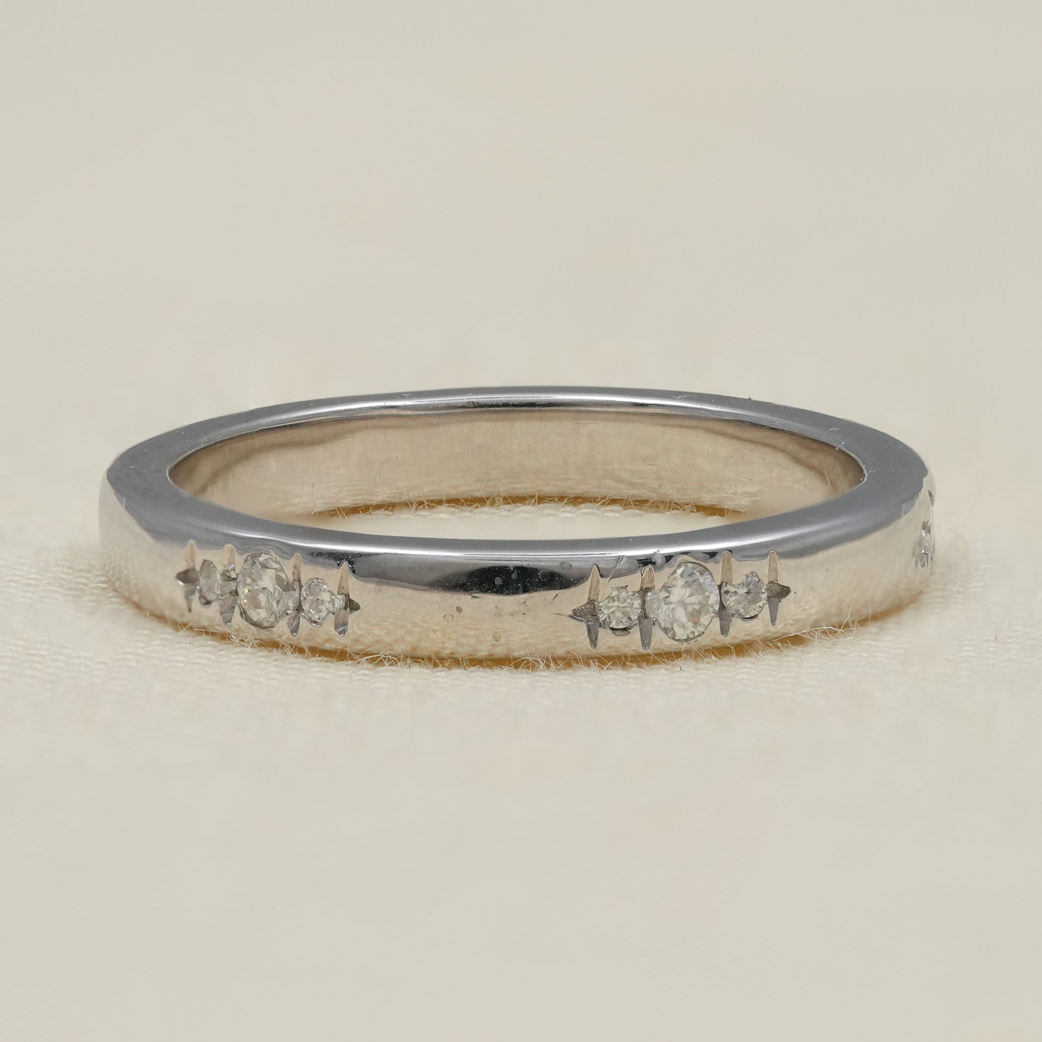 Minimal white gold band with flush set round diamonds