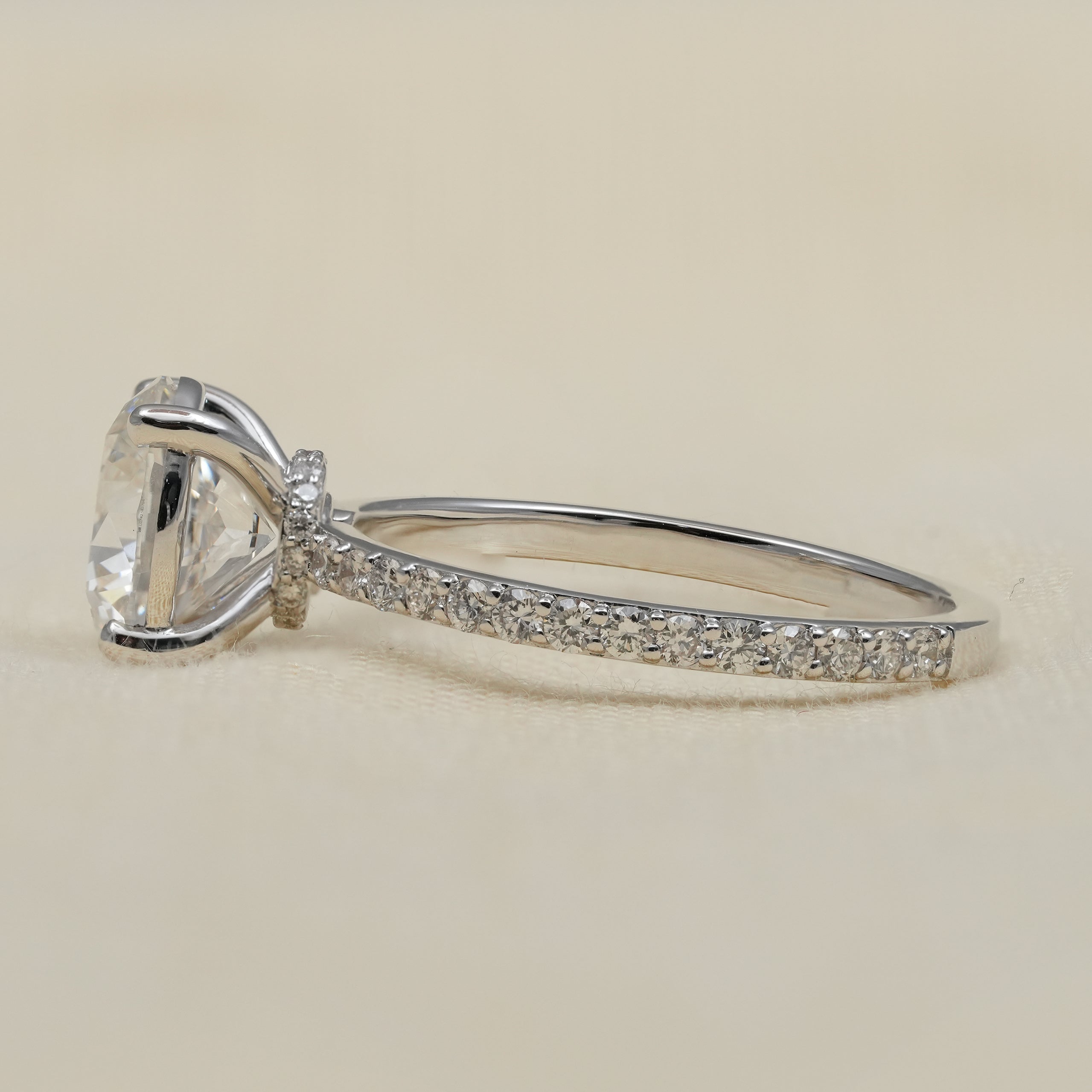 White gold engagement ring with round center diamond and pavé