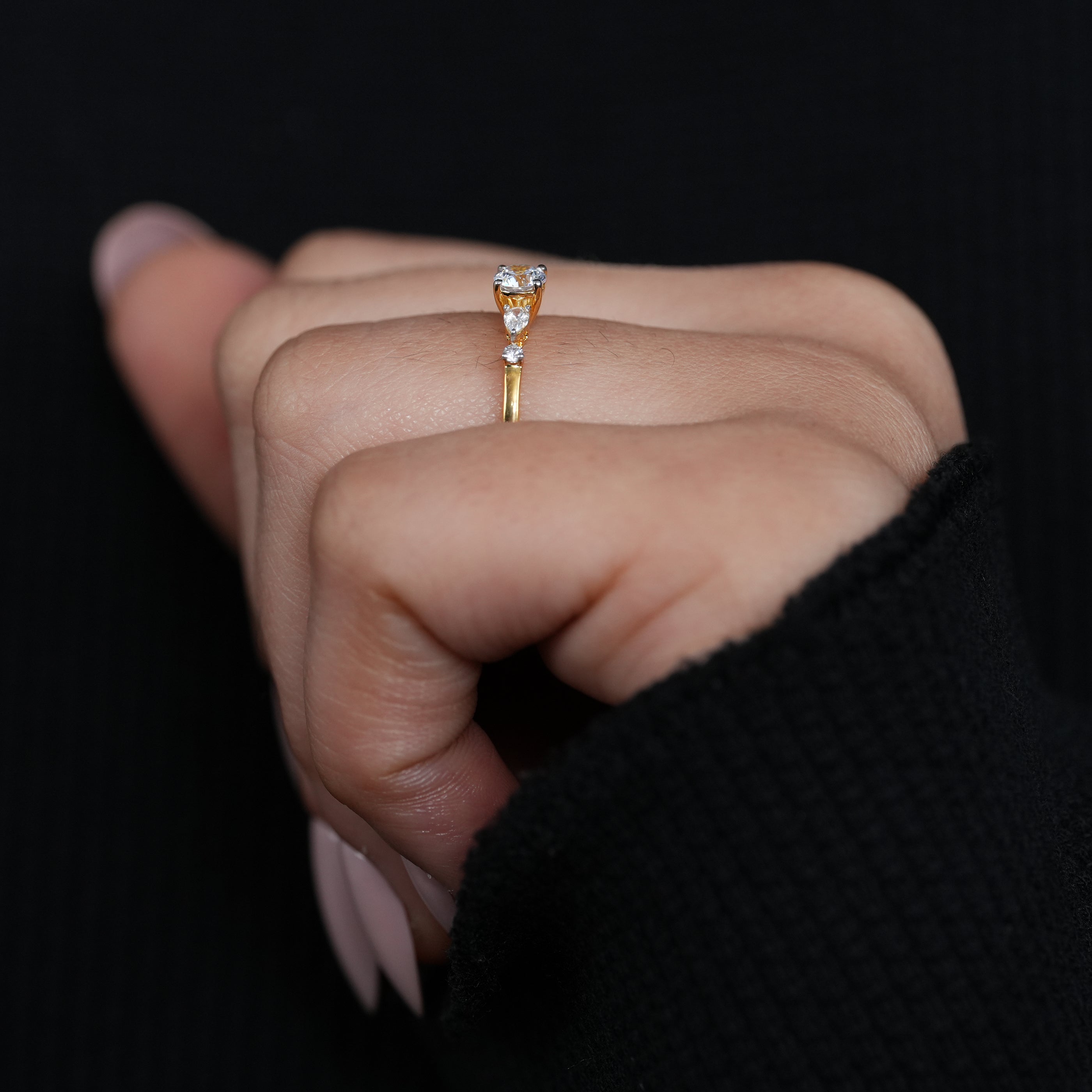 Modern three stone lab grown diamond ring with round center and pear accents
