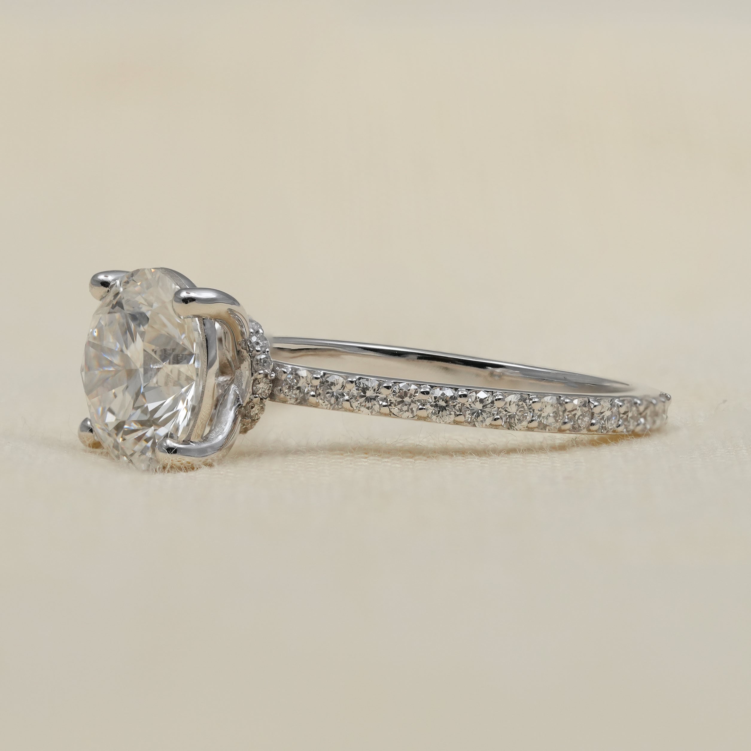 Elegant round brilliant diamond ring with delicate pavé band