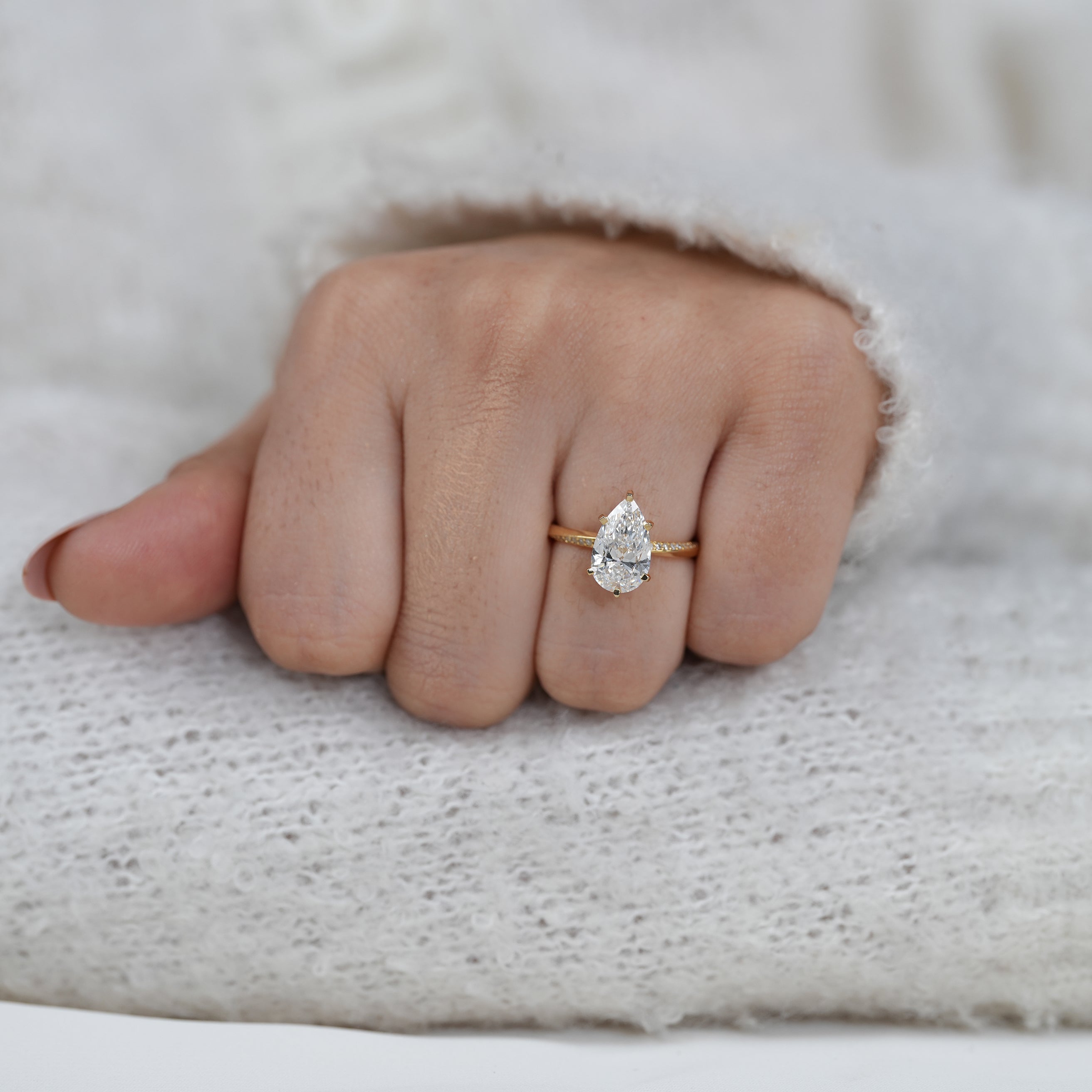 Pear lab grown diamond solitaire with delicate pavé yellow gold band