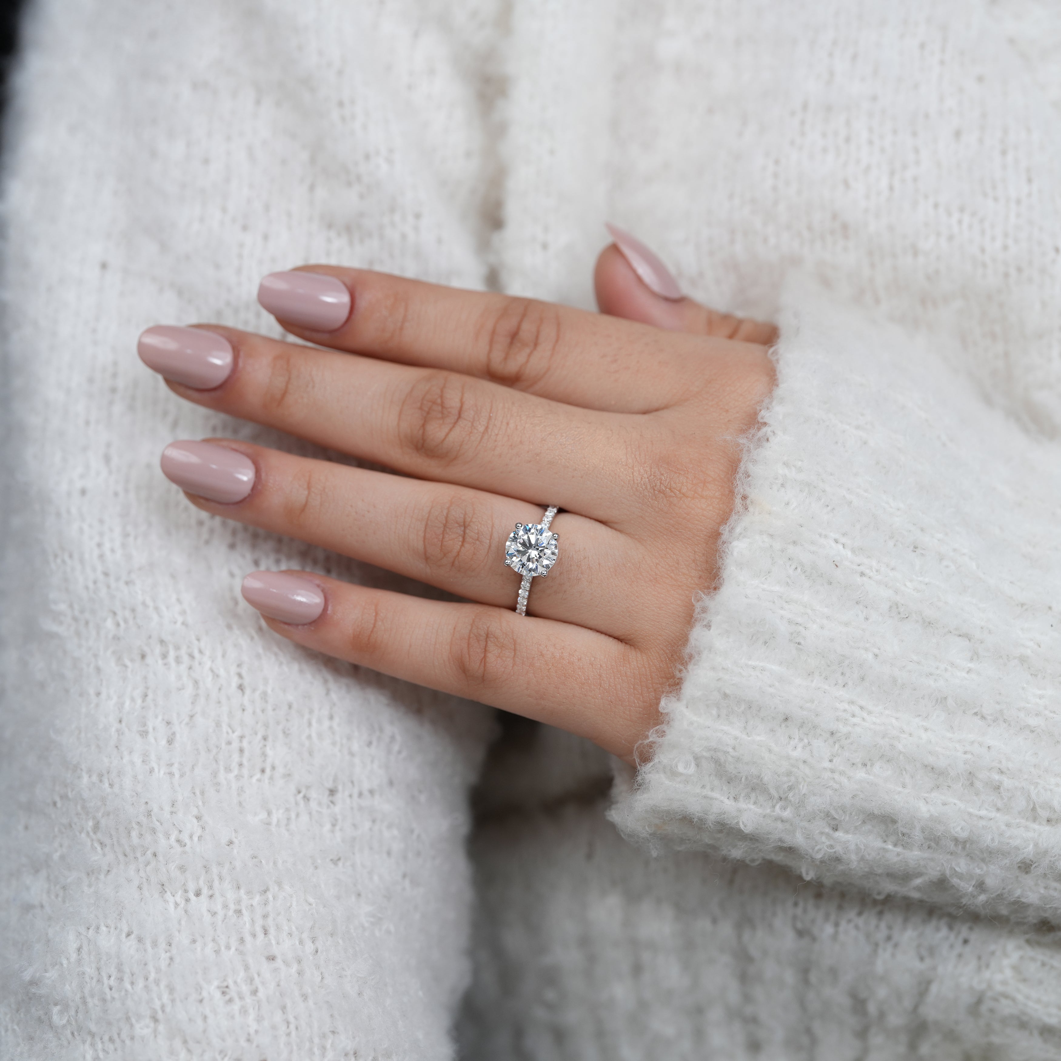 Fine round brilliant diamond ring with sparkling pavé shoulders