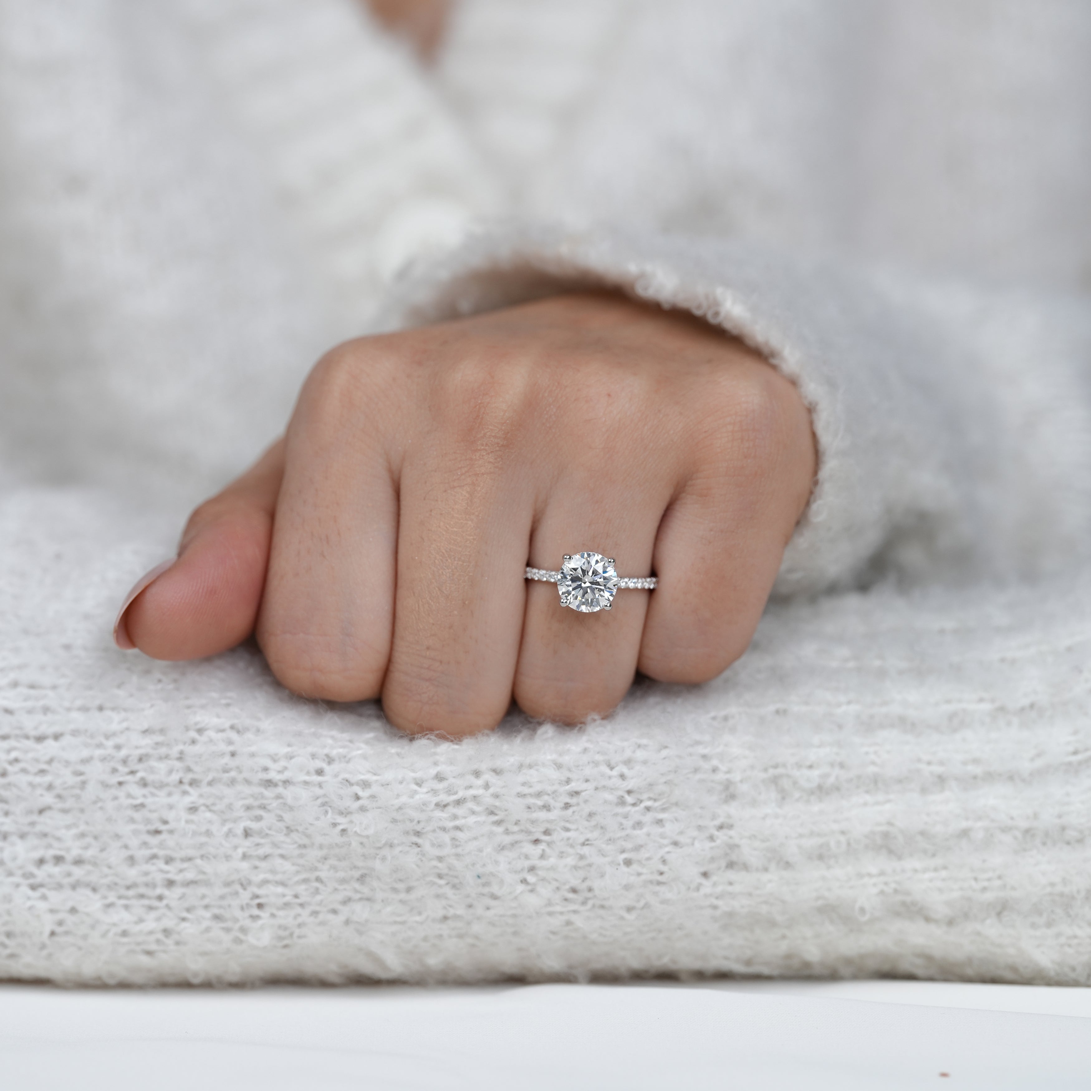Delicate engagement ring with round diamond and diamond band