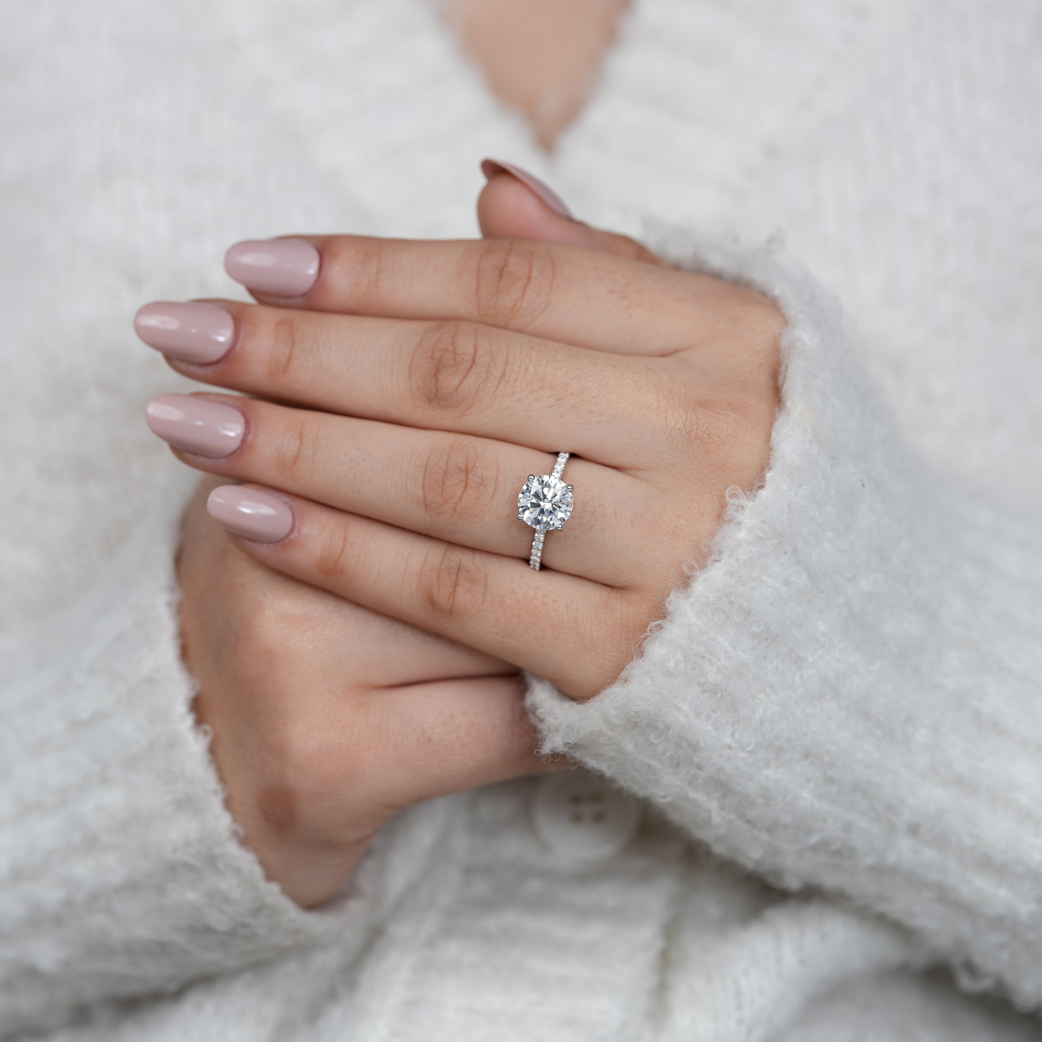 White gold solitaire ring with round diamond and pavé band