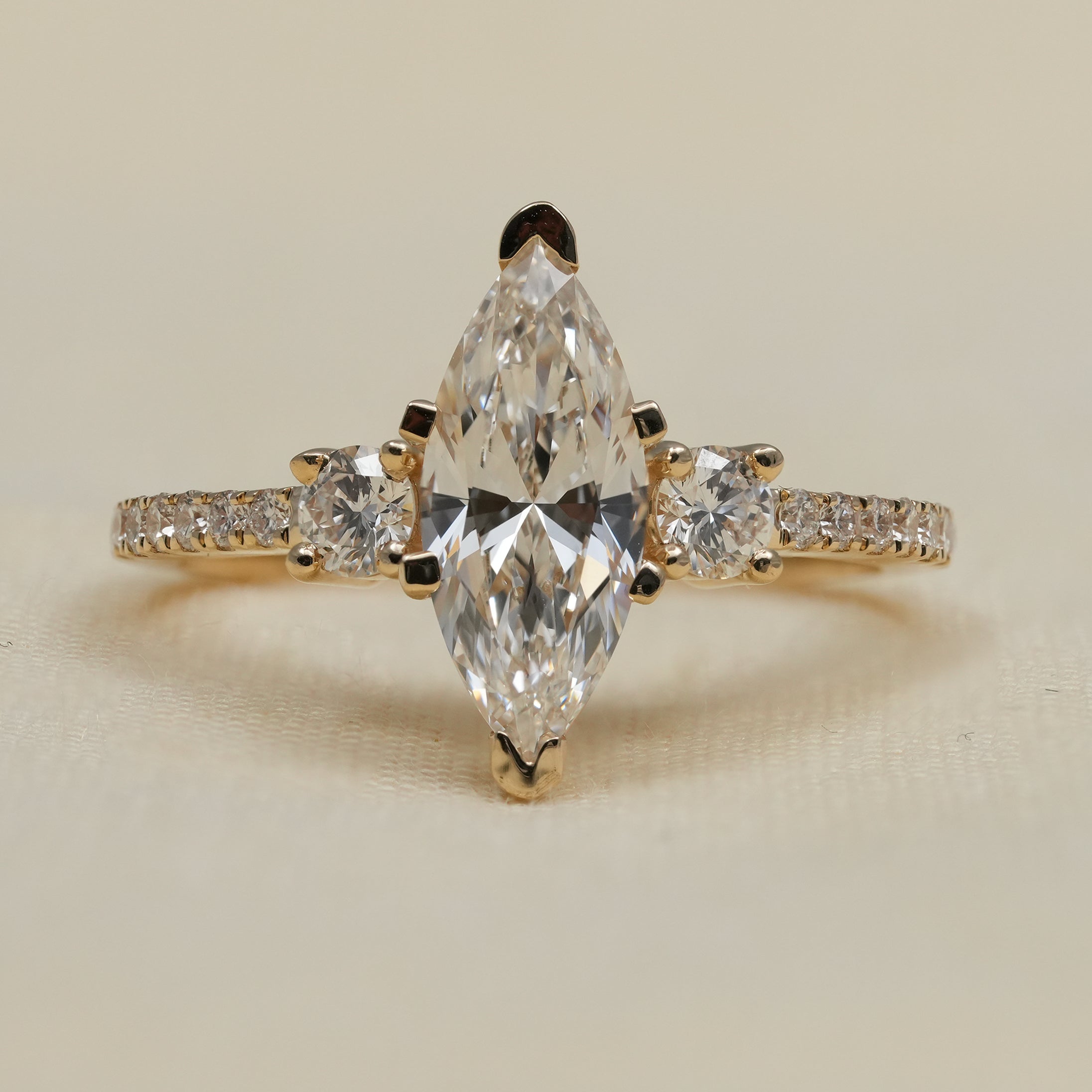 Marquise lab grown diamond engagement ring with yellow gold pavé band