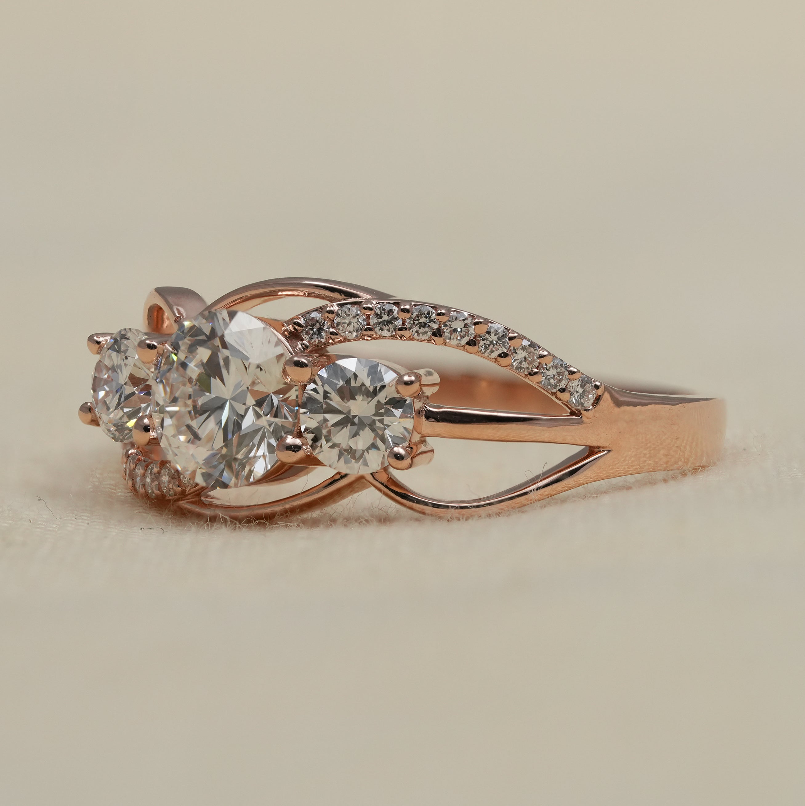 Elegant three stone lab grown diamond ring with rose gold pavé accents
