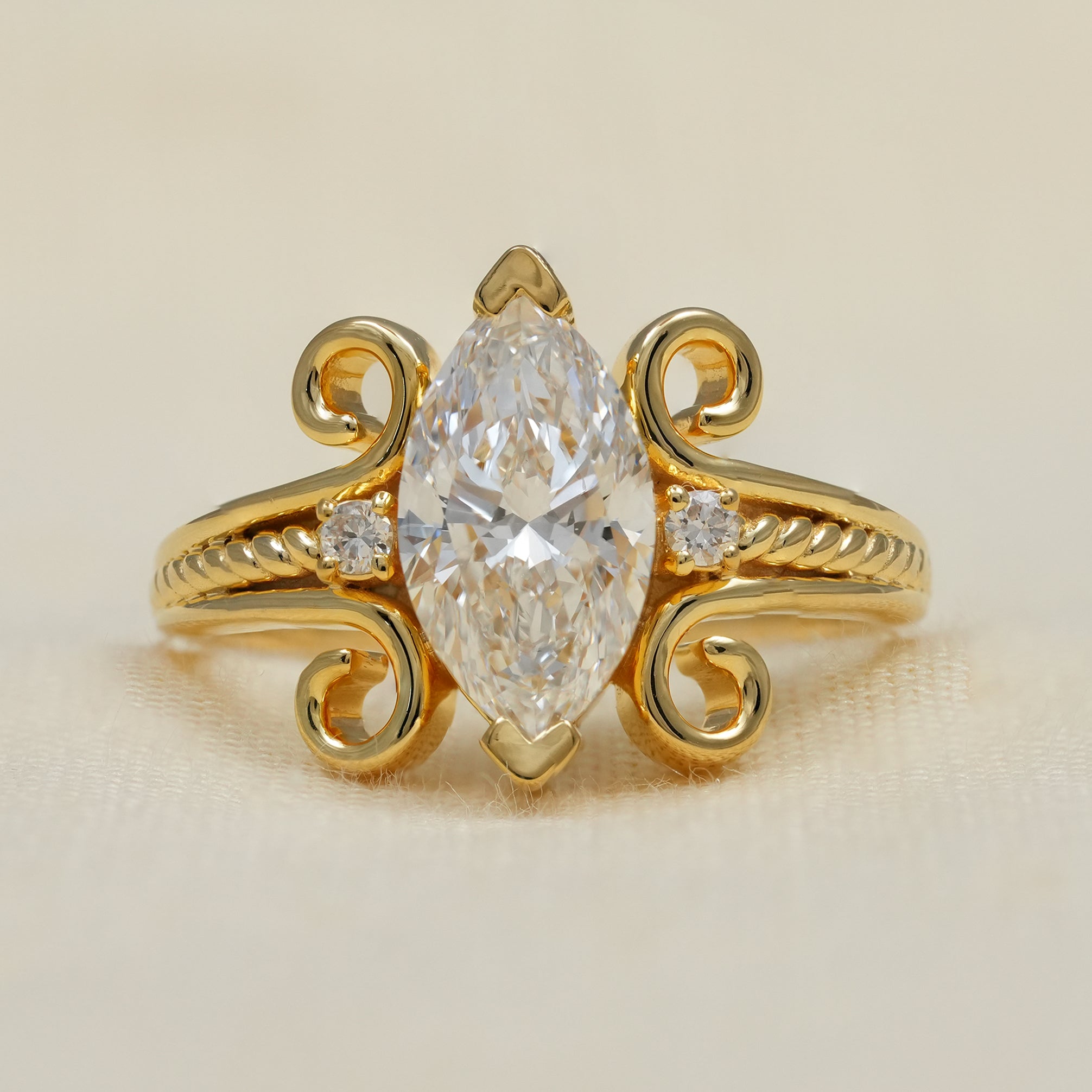 Vintage marquise lab grown diamond engagement ring with ornate yellow gold scrolls