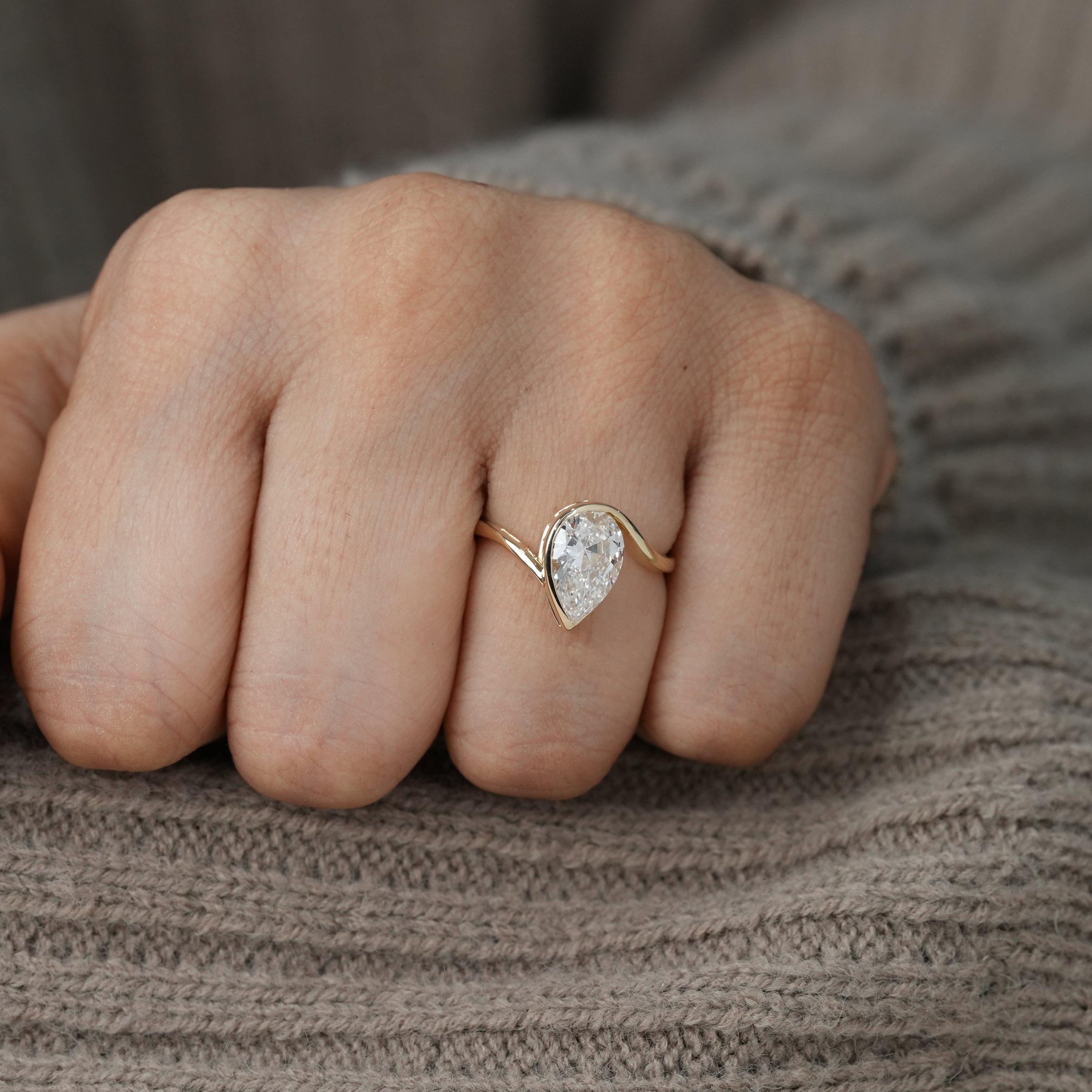 Contemporary pear lab grown diamond wrap setting with flowing gold band