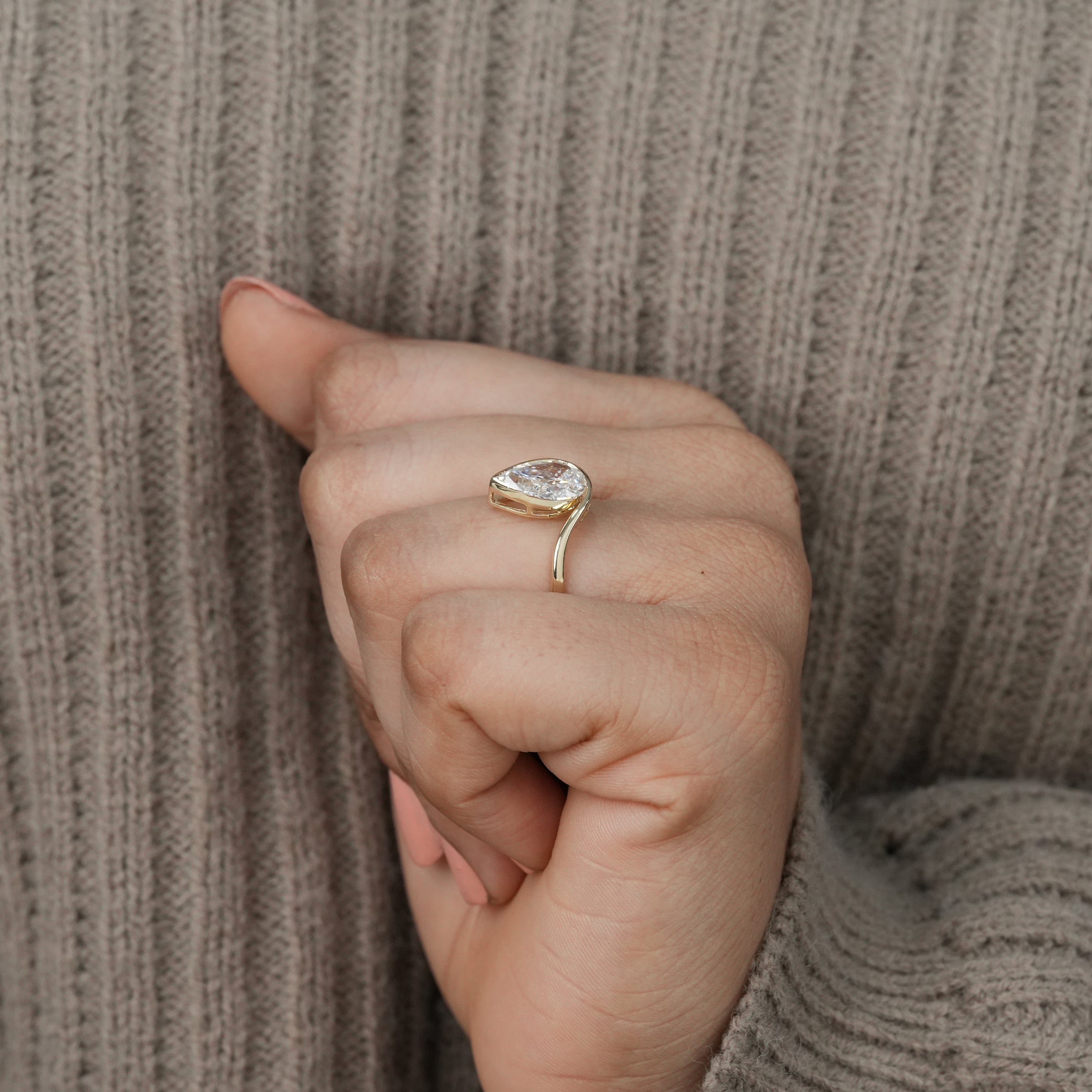 Artistic wave gold ring featuring pear lab grown diamond centerpiece