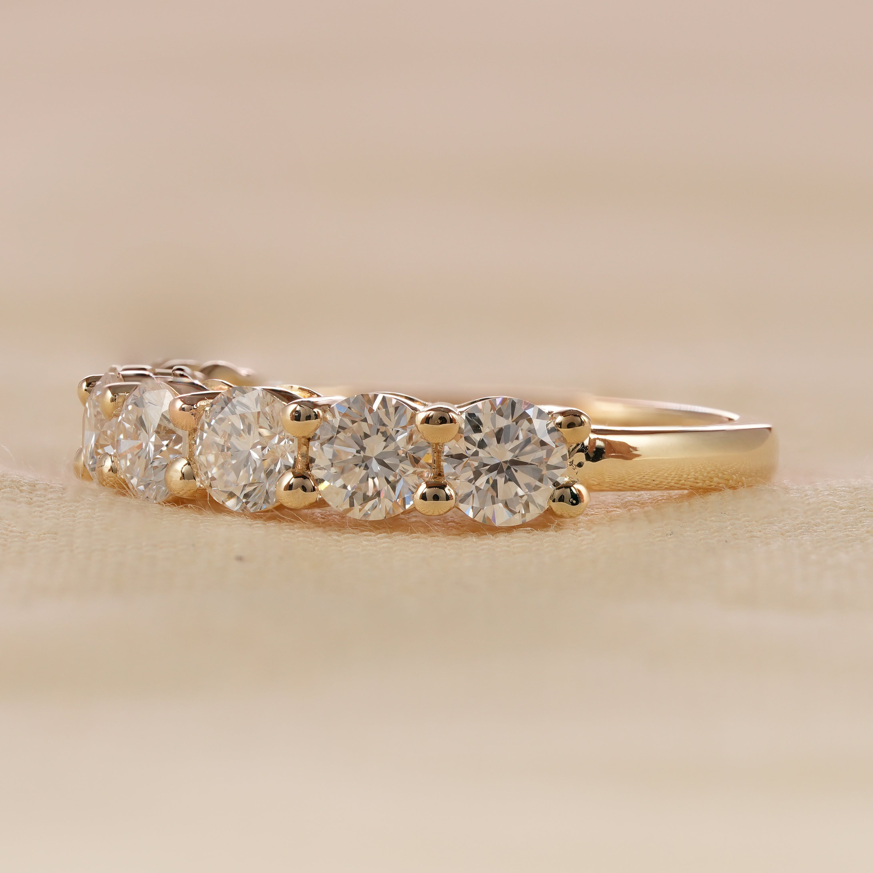 Round cut diamond wedding band with shared prong yellow gold setting