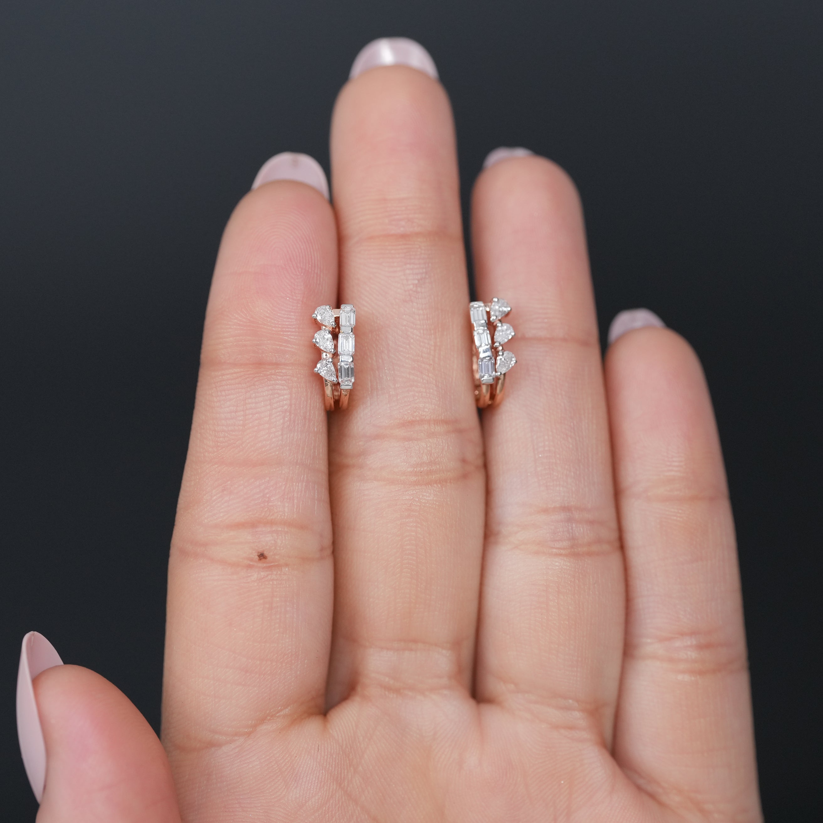 Modern lab grown diamond huggie earrings styled on ear close up