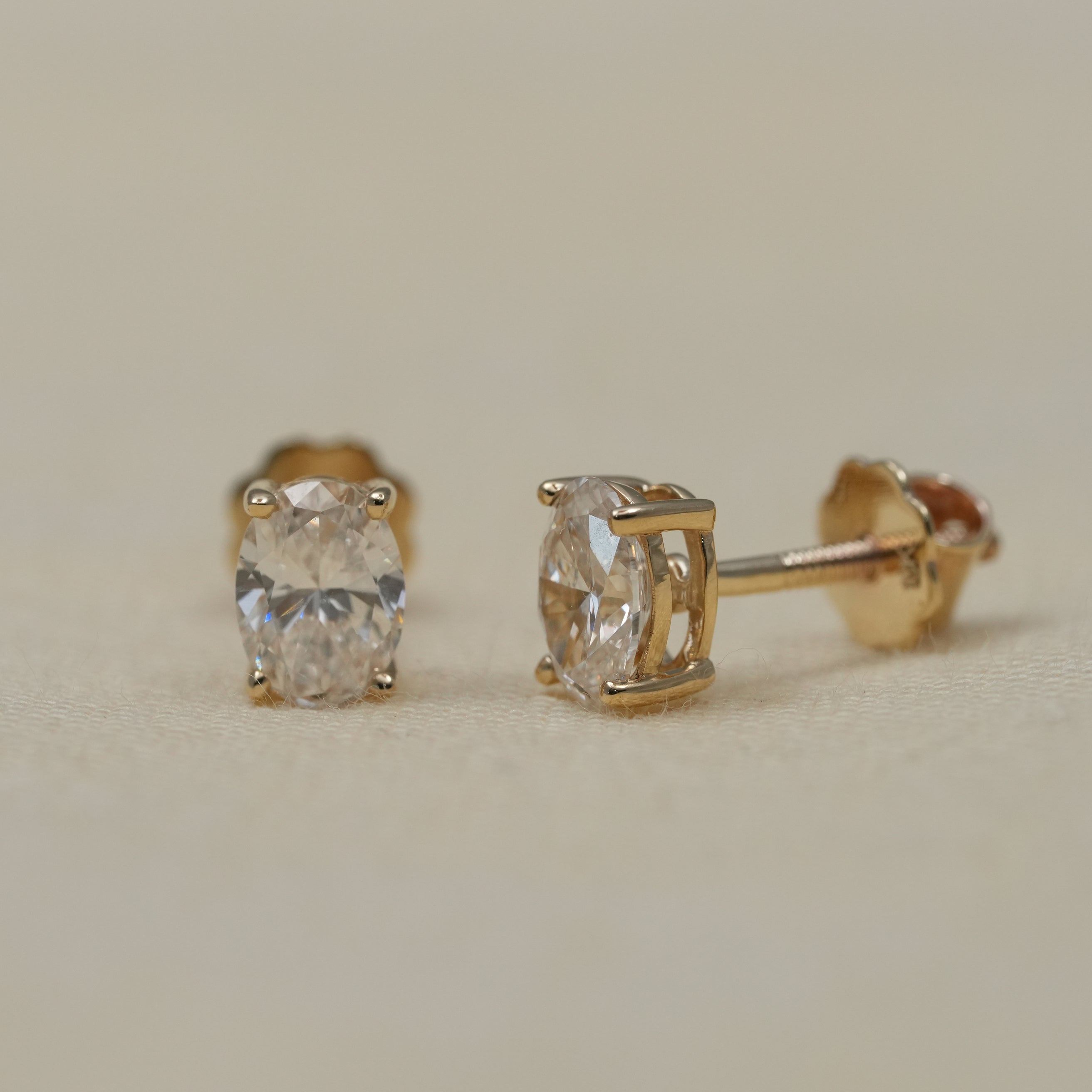 Modern oval lab grown diamond stud earrings in sleek yellow gold prong mountings