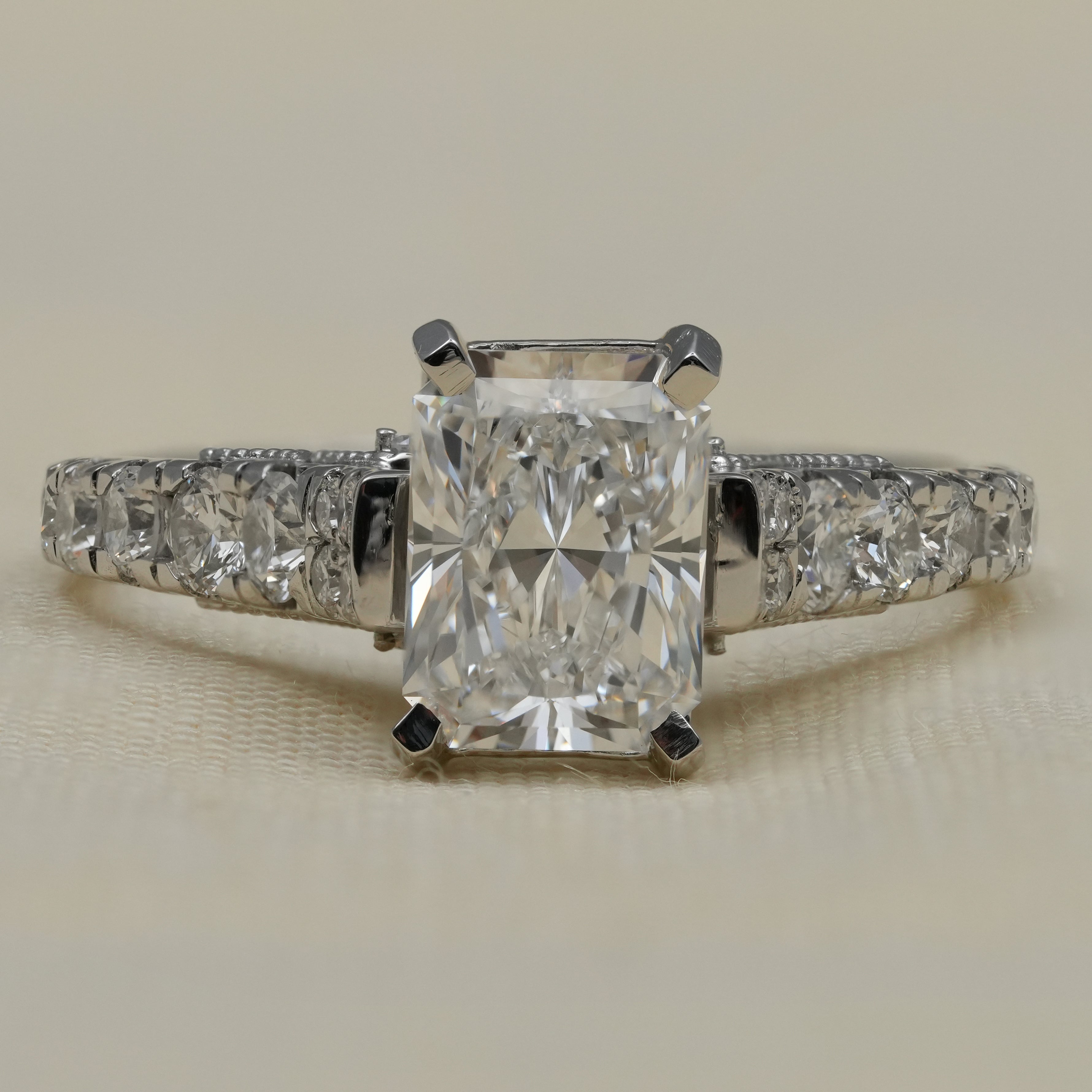 Radiant cut lab grown diamond engagement ring with tapered side stones.