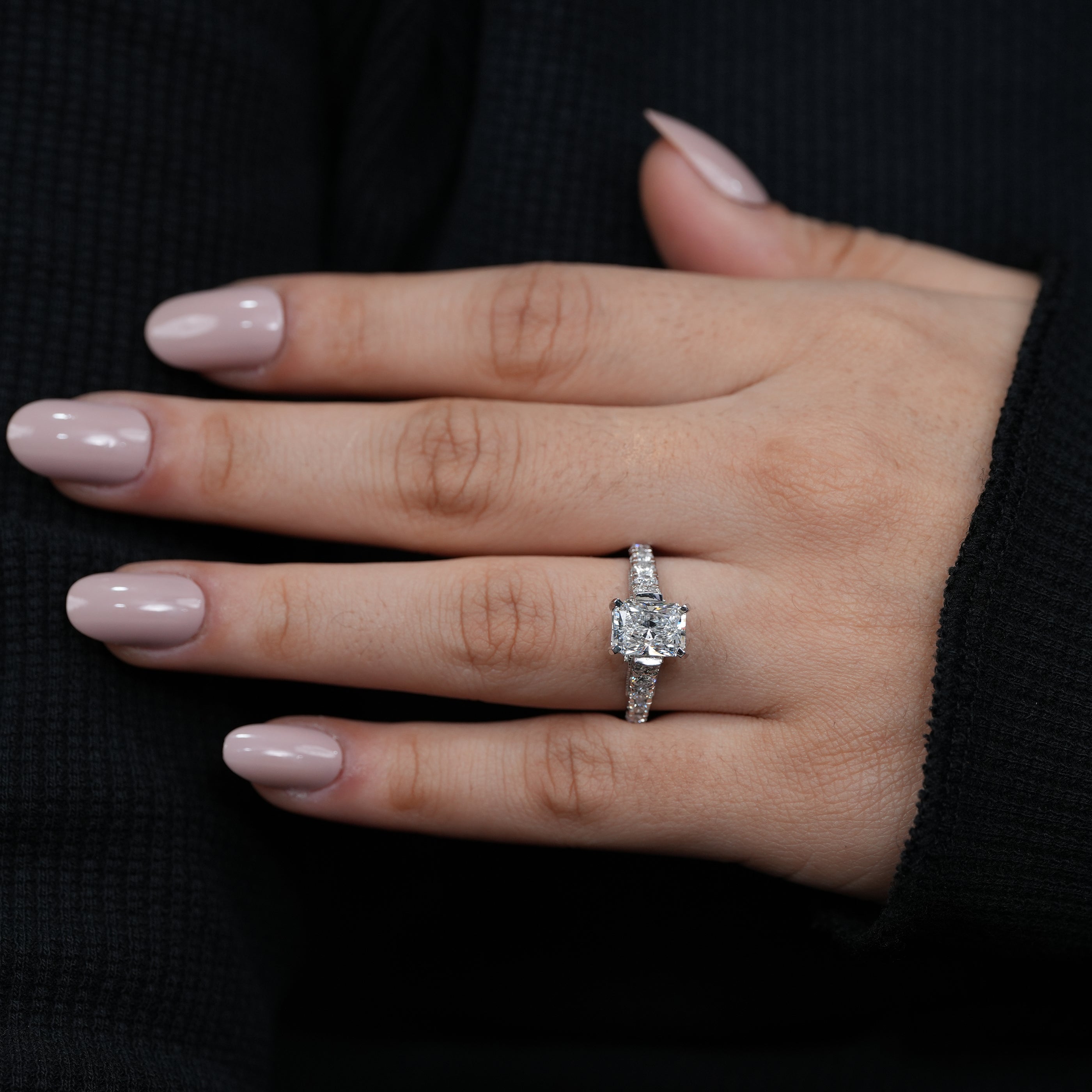 Rectangular radiant lab grown diamond solitaire ring with sparkling side diamonds.