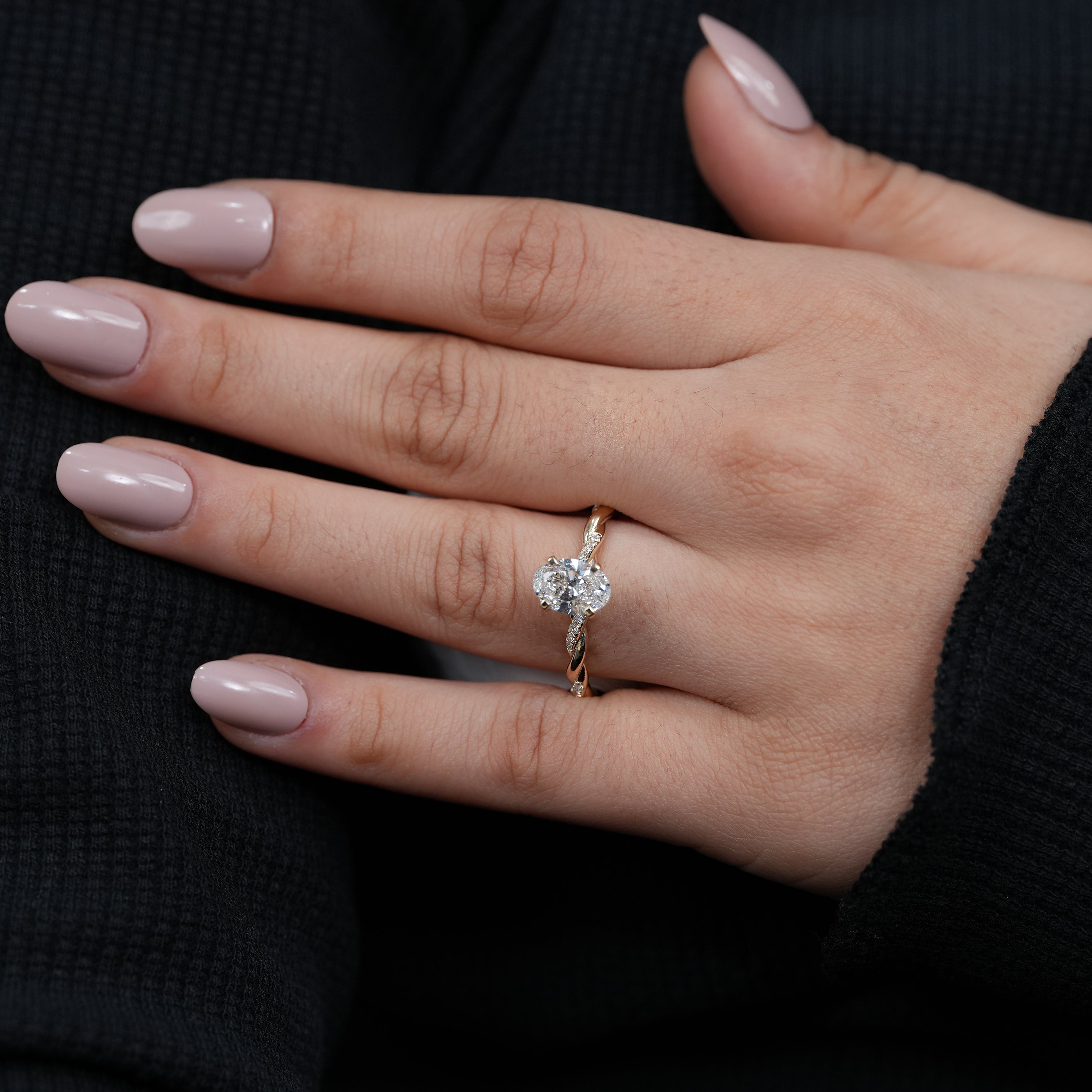 Twisted yellow gold engagement ring featuring oval lab grown diamond center