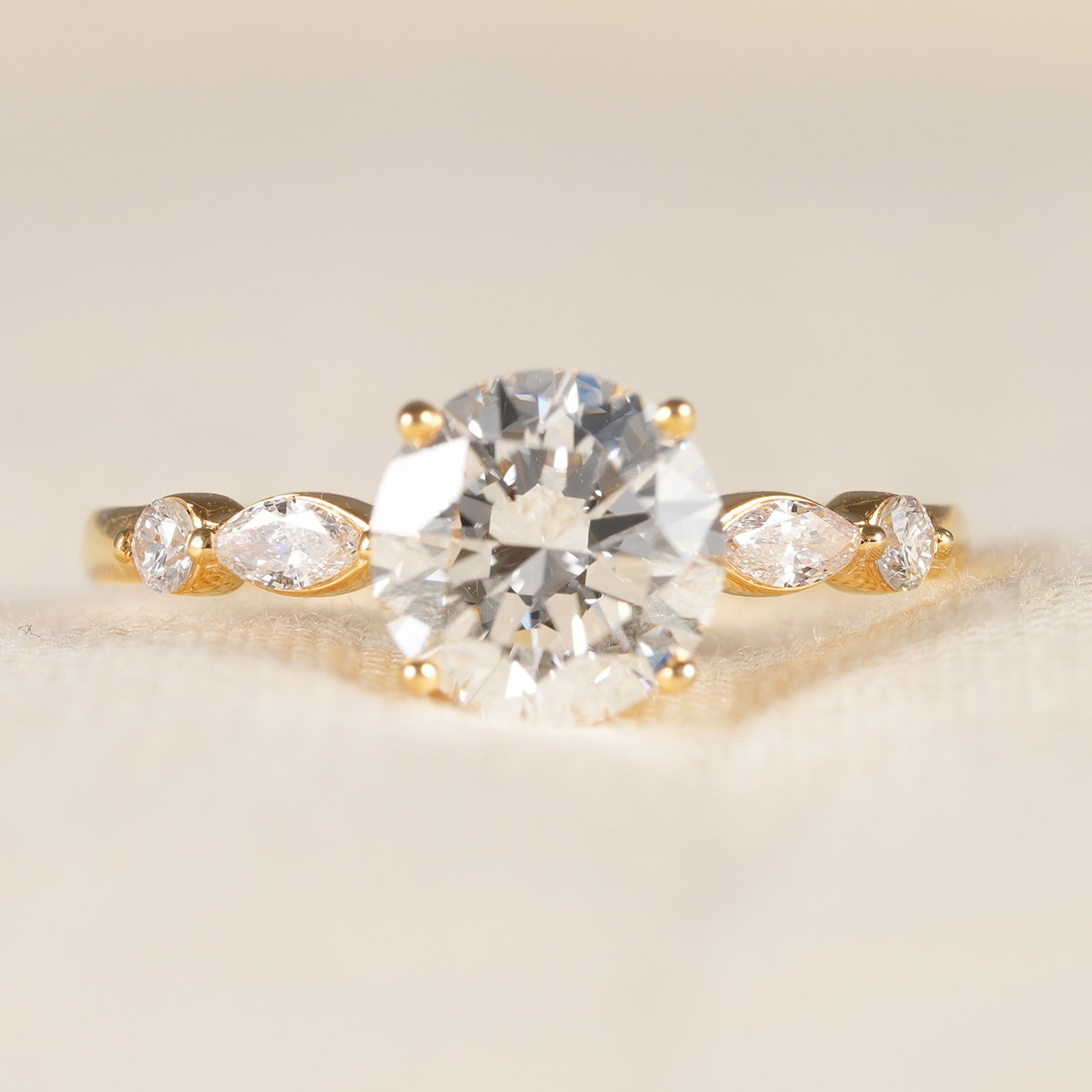 Round diamond engagement ring with marquise and round diamond accents