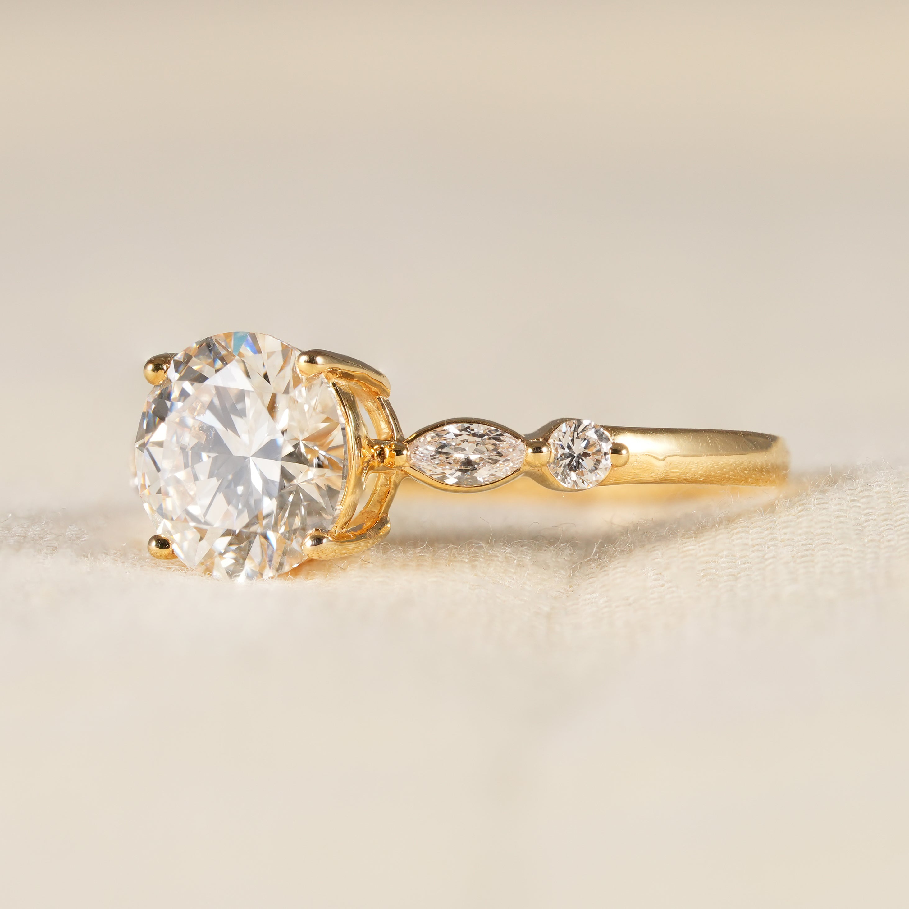 Elegant round solitaire diamond ring with marquise side diamond band