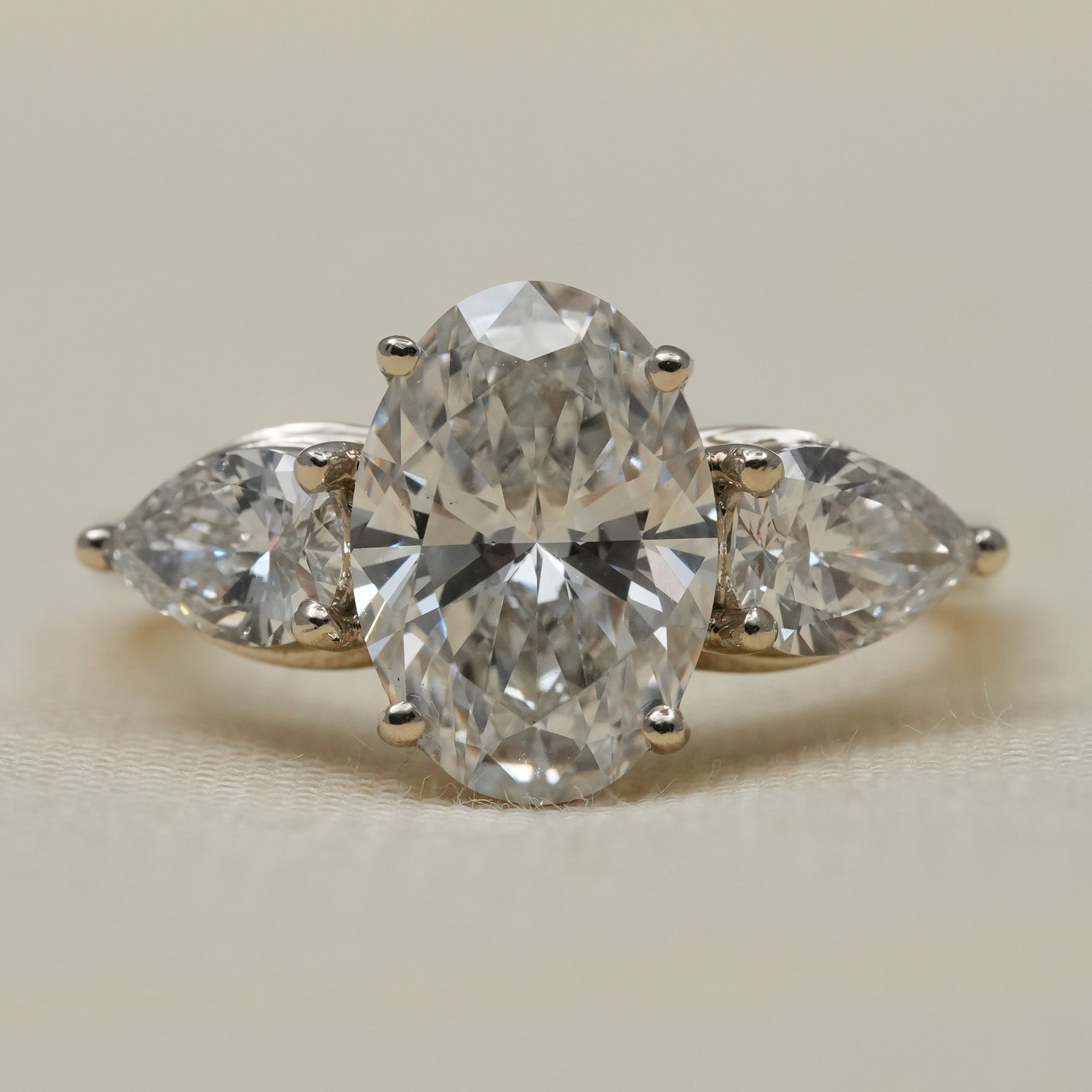 Oval lab grown diamond three stone engagement ring with pear side diamonds