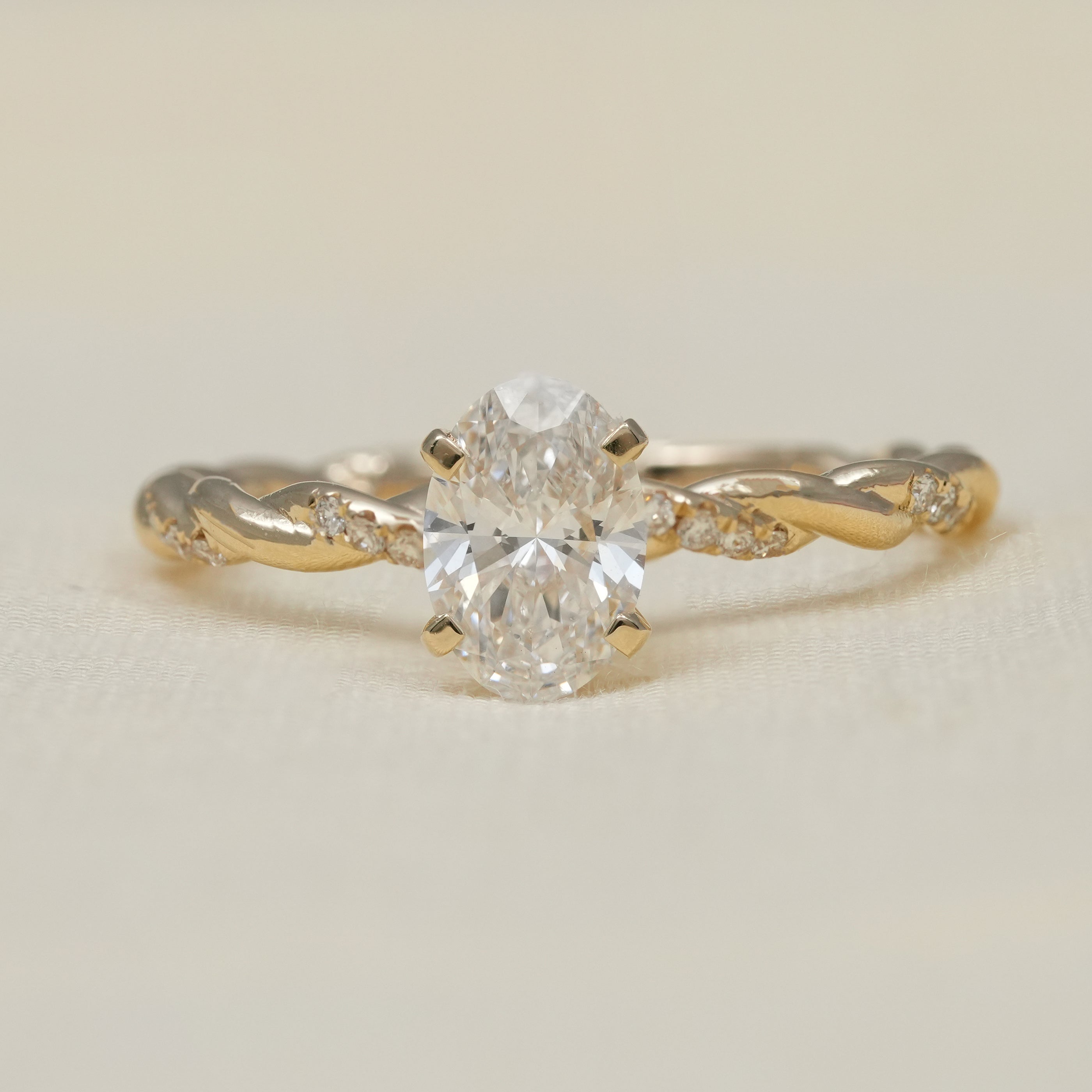 Oval lab grown diamond solitaire engagement ring twisted yellow gold band