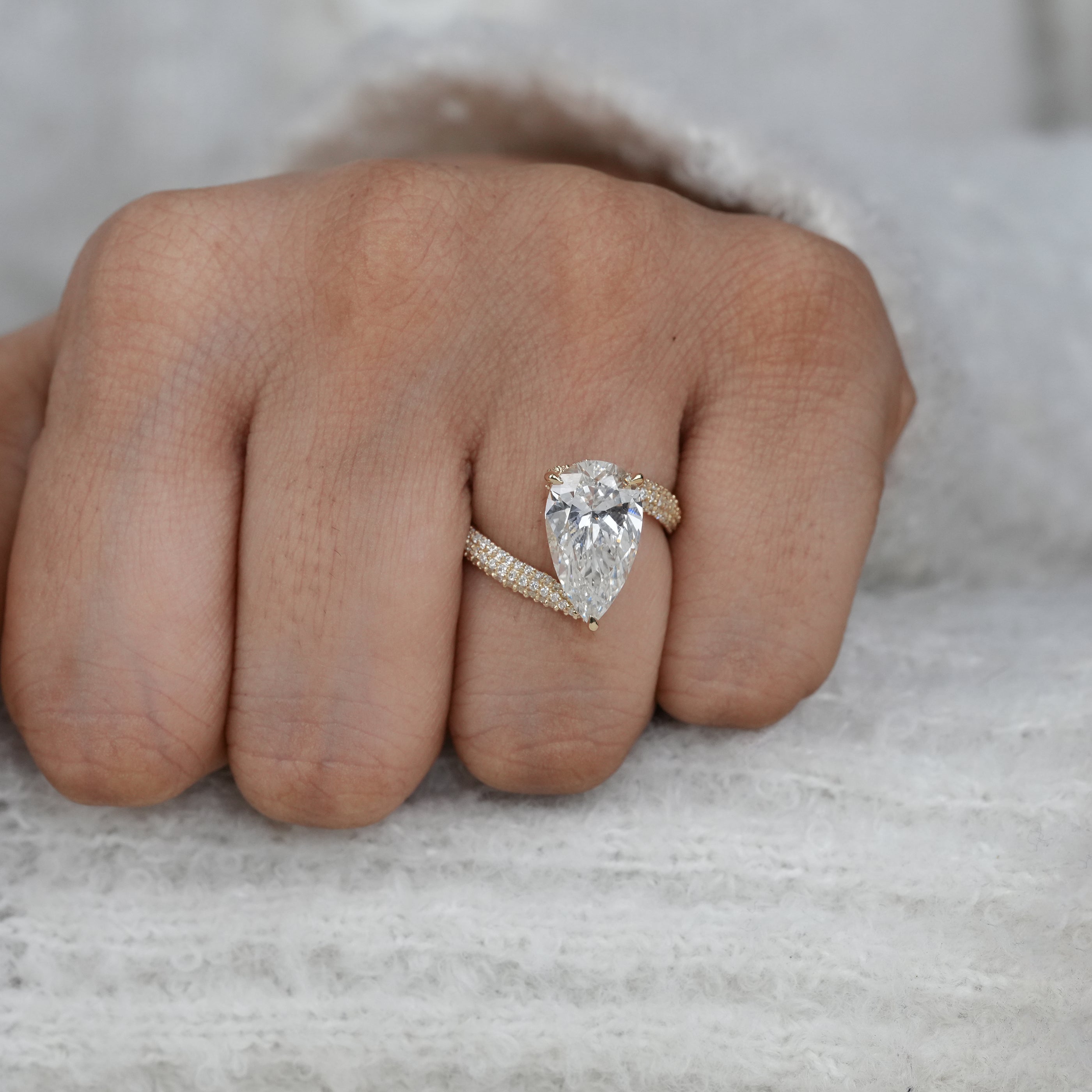 Close up pear lab grown diamond ring with fully pavé set band