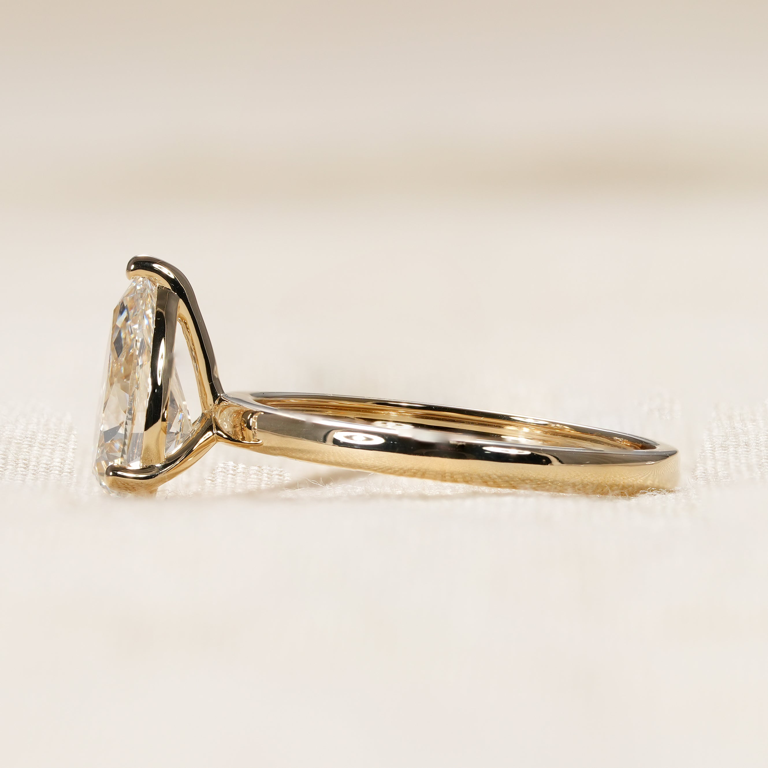 Minimalist pear shaped diamond ring with classic yellow gold design