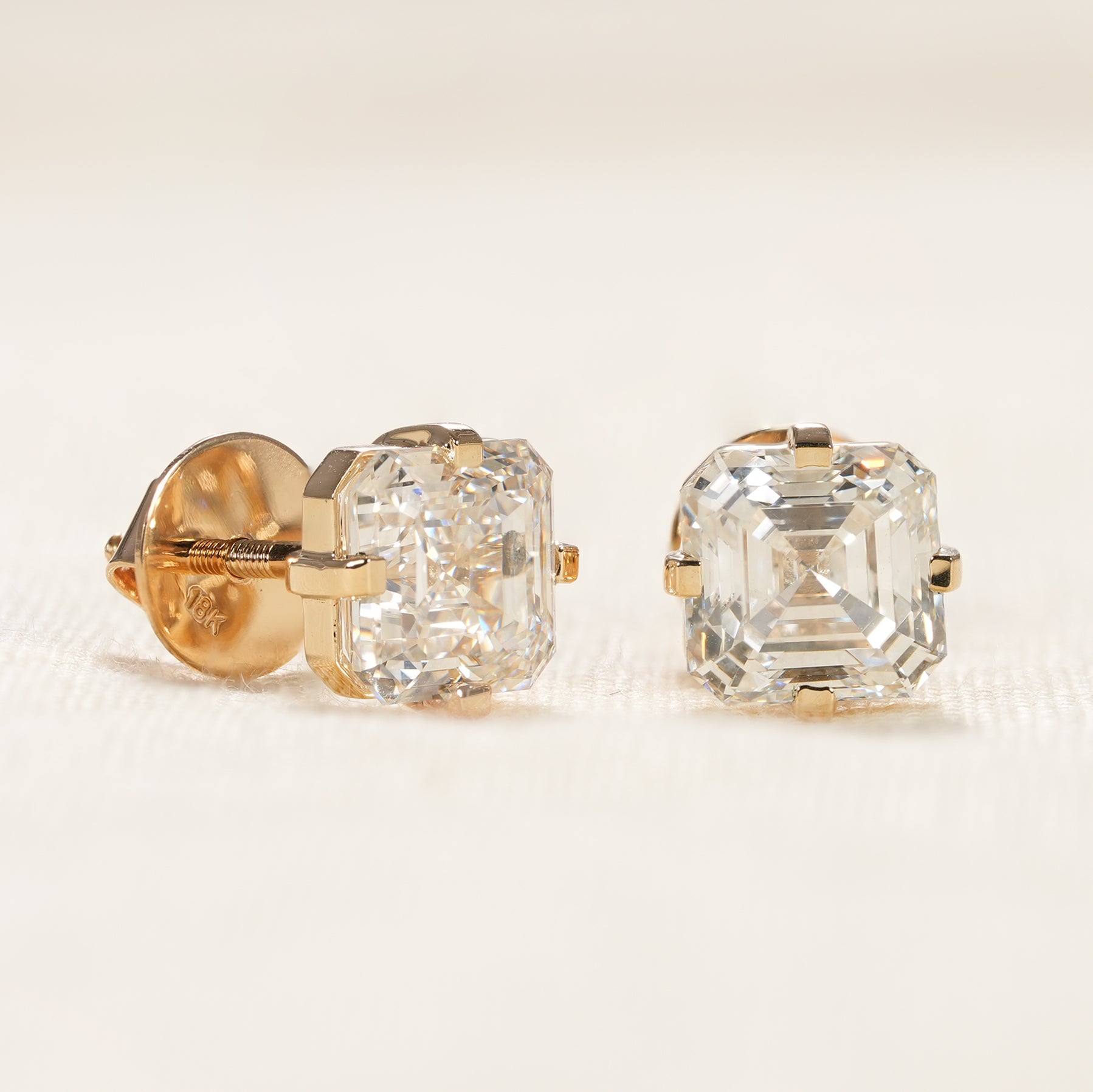 Elegant Asscher diamond stud earrings with timeless yellow gold prongs