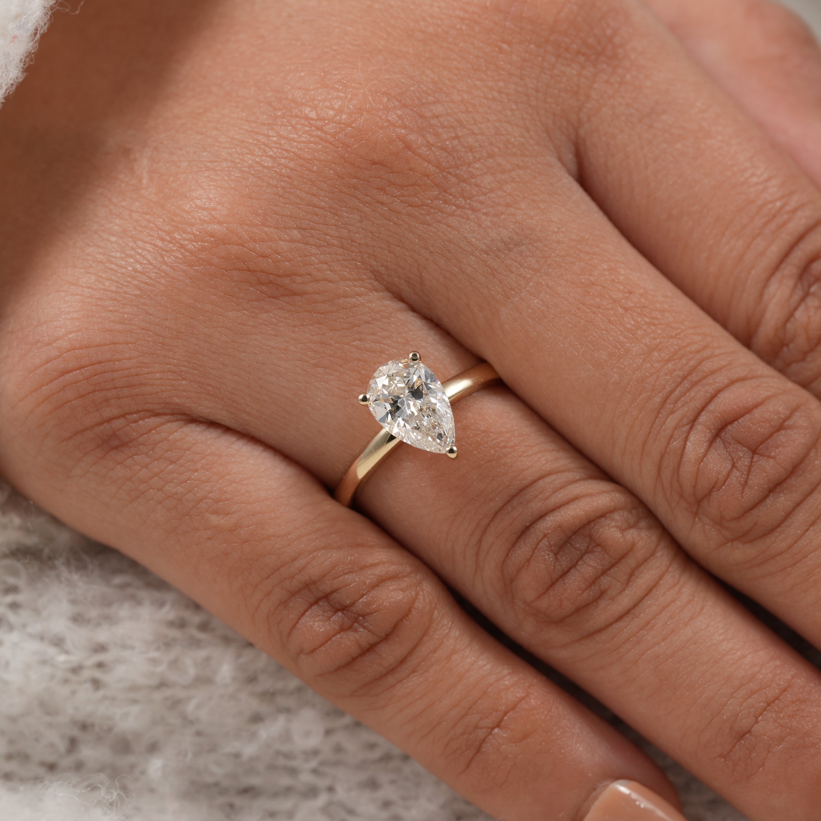 Modern pear cut diamond engagement ring with elegant gold solitaire style
