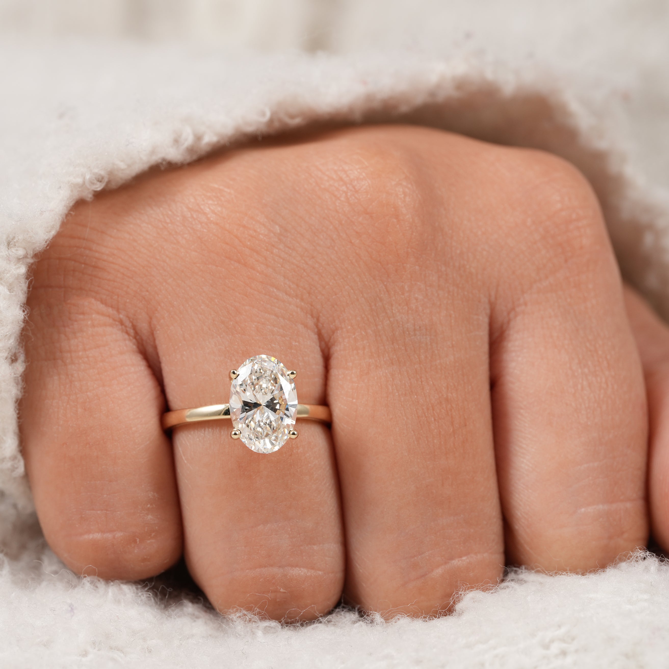 Four prong oval diamond engagement ring with refined gold solitaire setting
