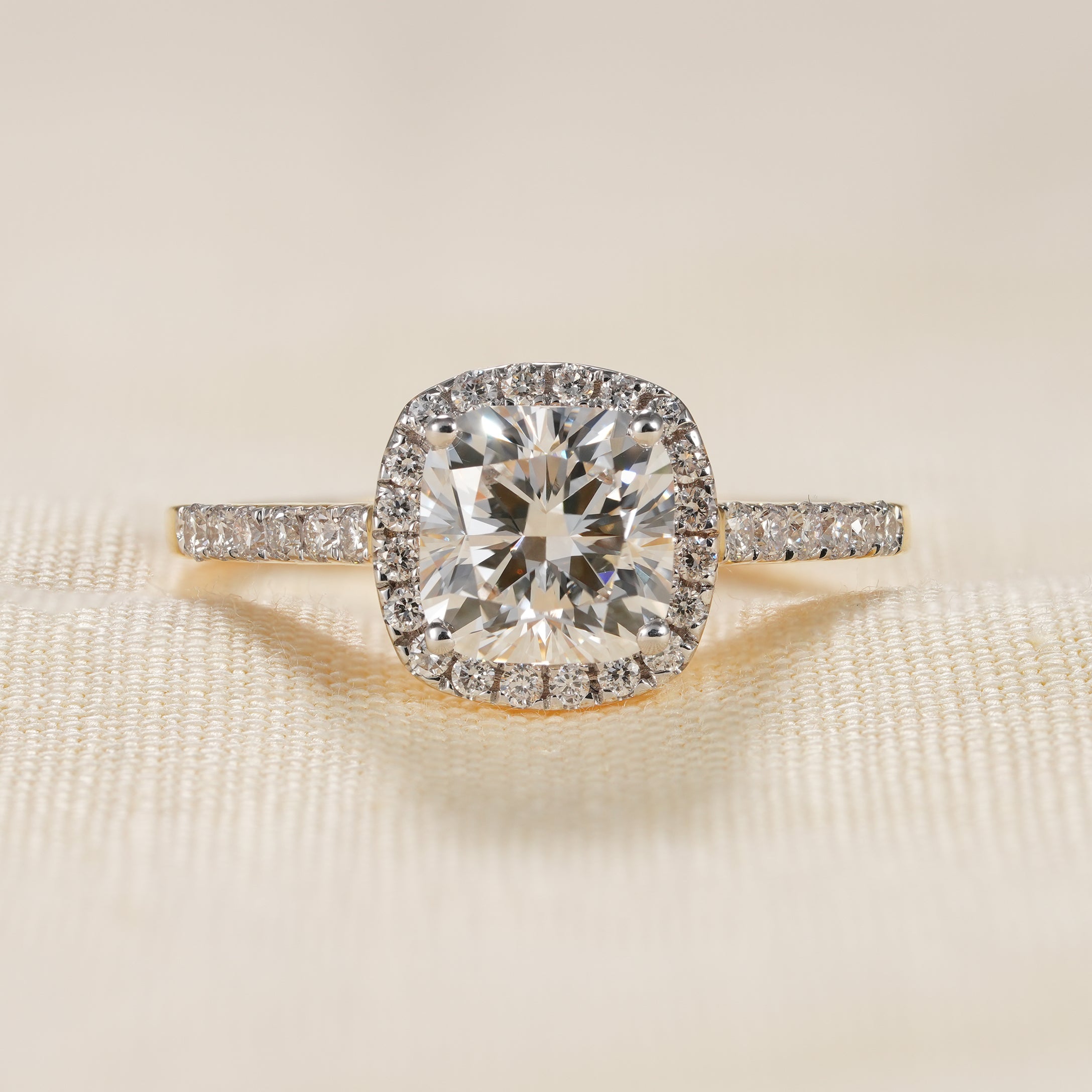 Cushion cut lab diamond halo engagement ring with pavé yellow gold band