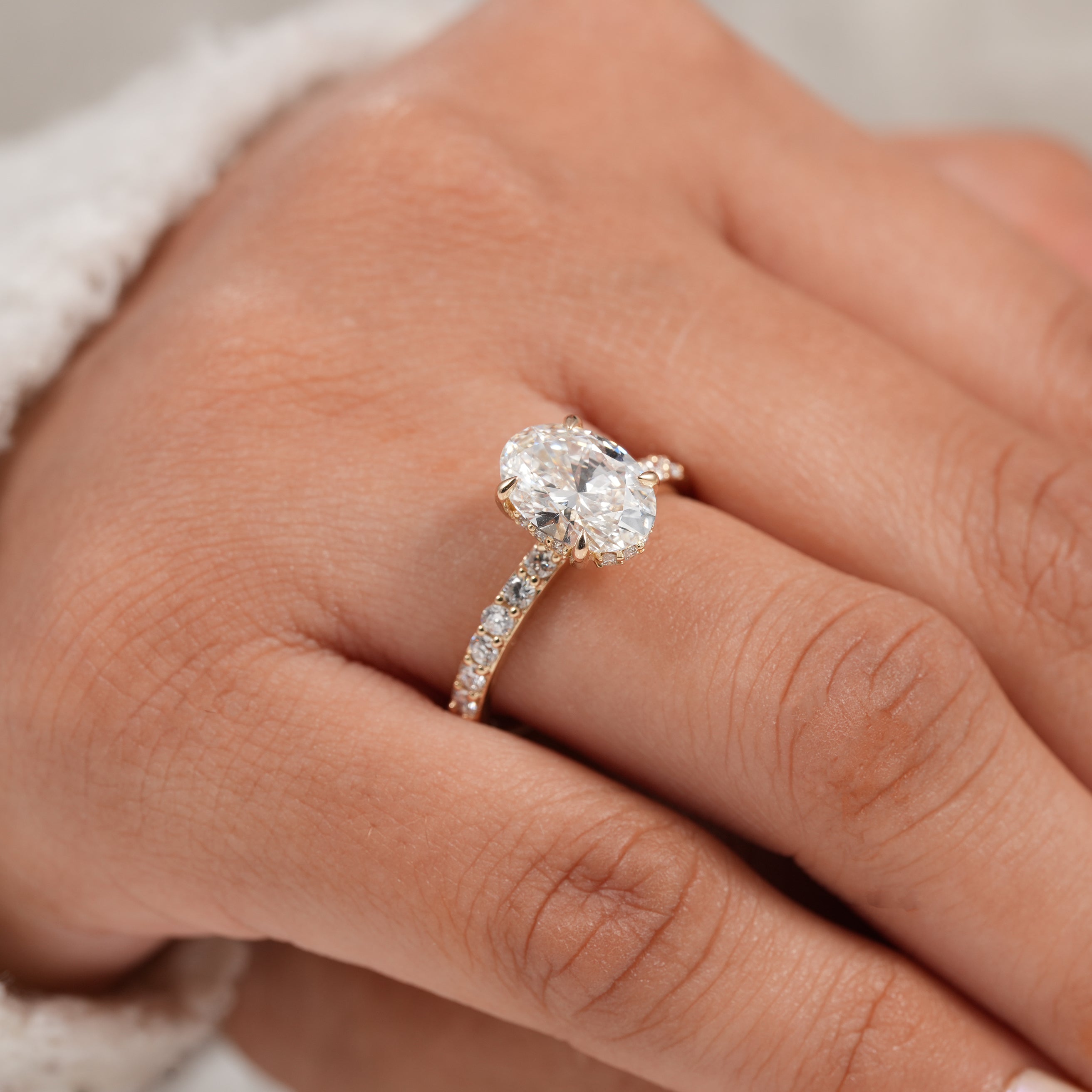 Timeless oval diamond engagement ring with diamond accented gold band