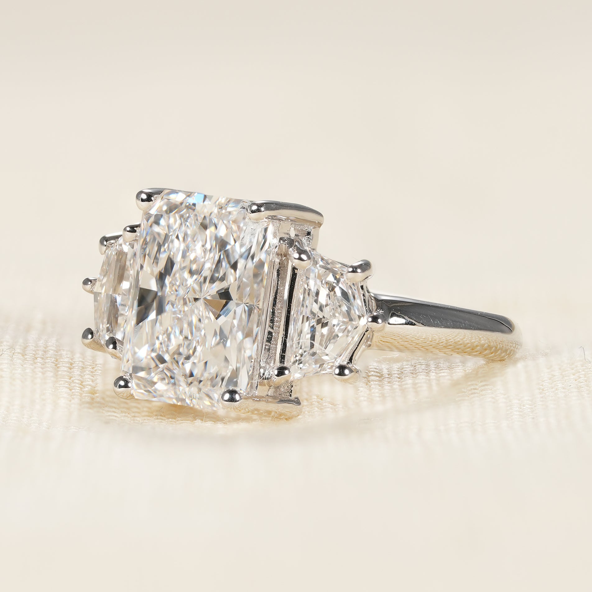 Three stone engagement ring with radiant center diamond and geometric Cadillac side stones