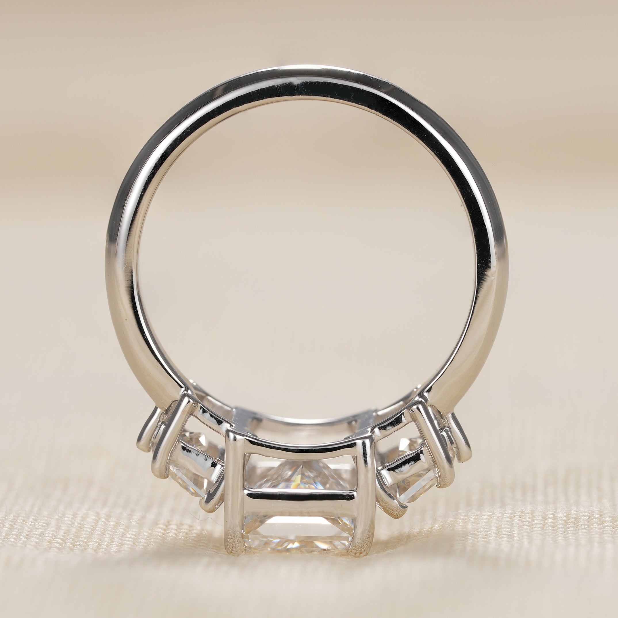 Statement three stone bridal ring with radiant cut center and tapered Cadillac side stones