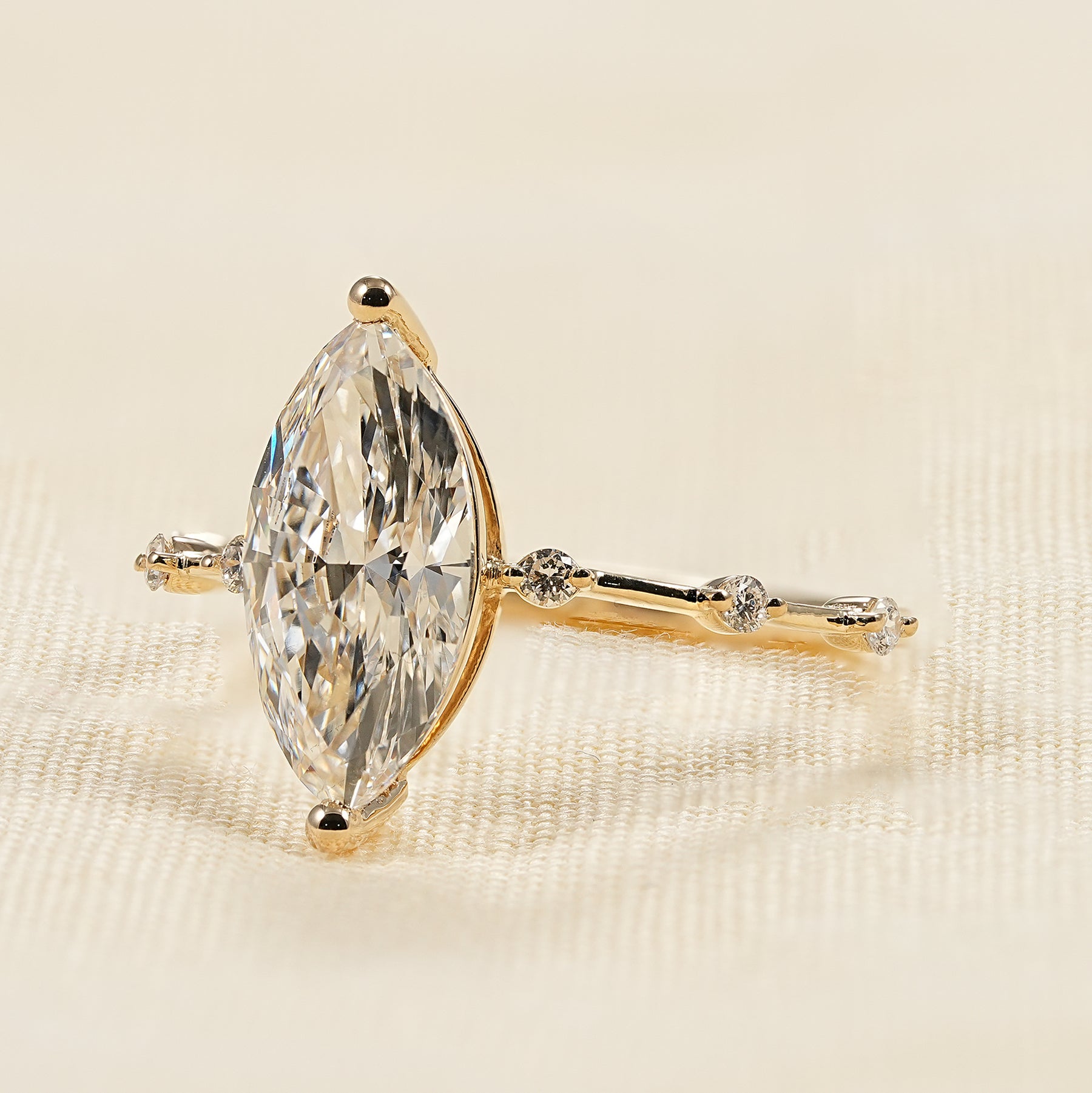 Elegant marquise solitaire engagement ring with yellow gold diamond accents