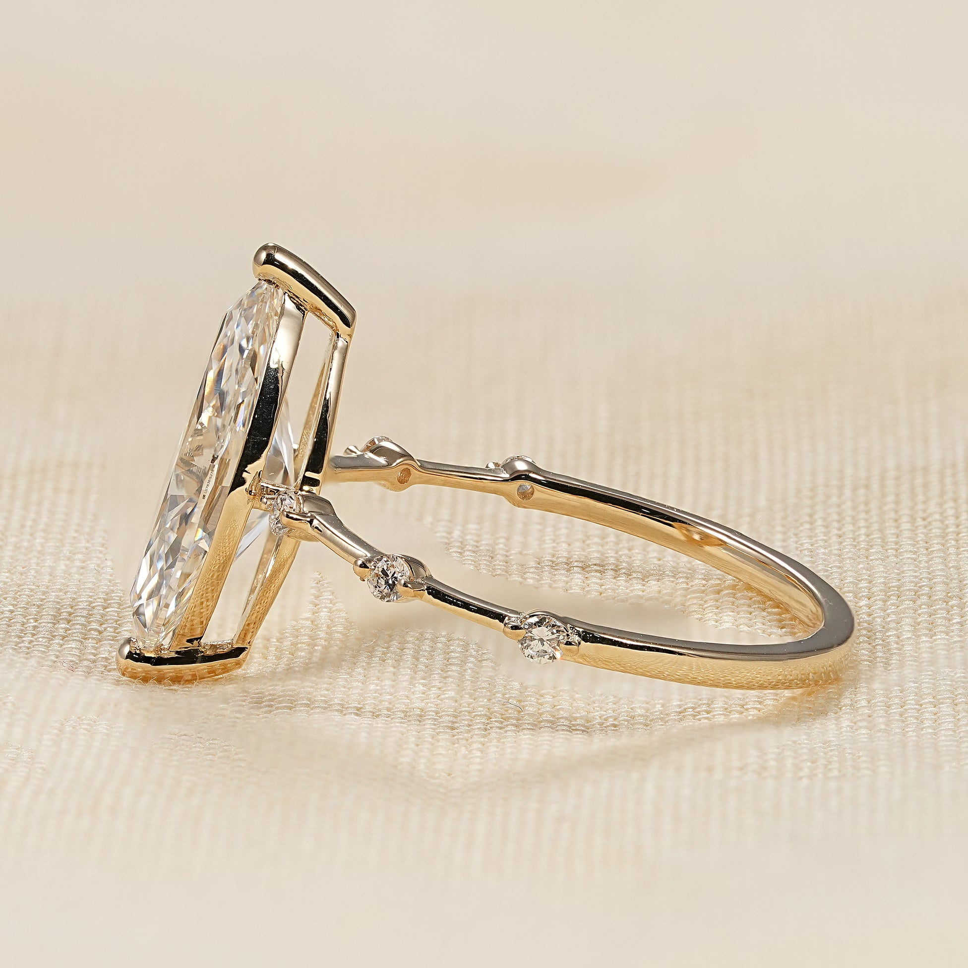Minimalist bridal ring featuring marquise cut center stone and spaced diamonds