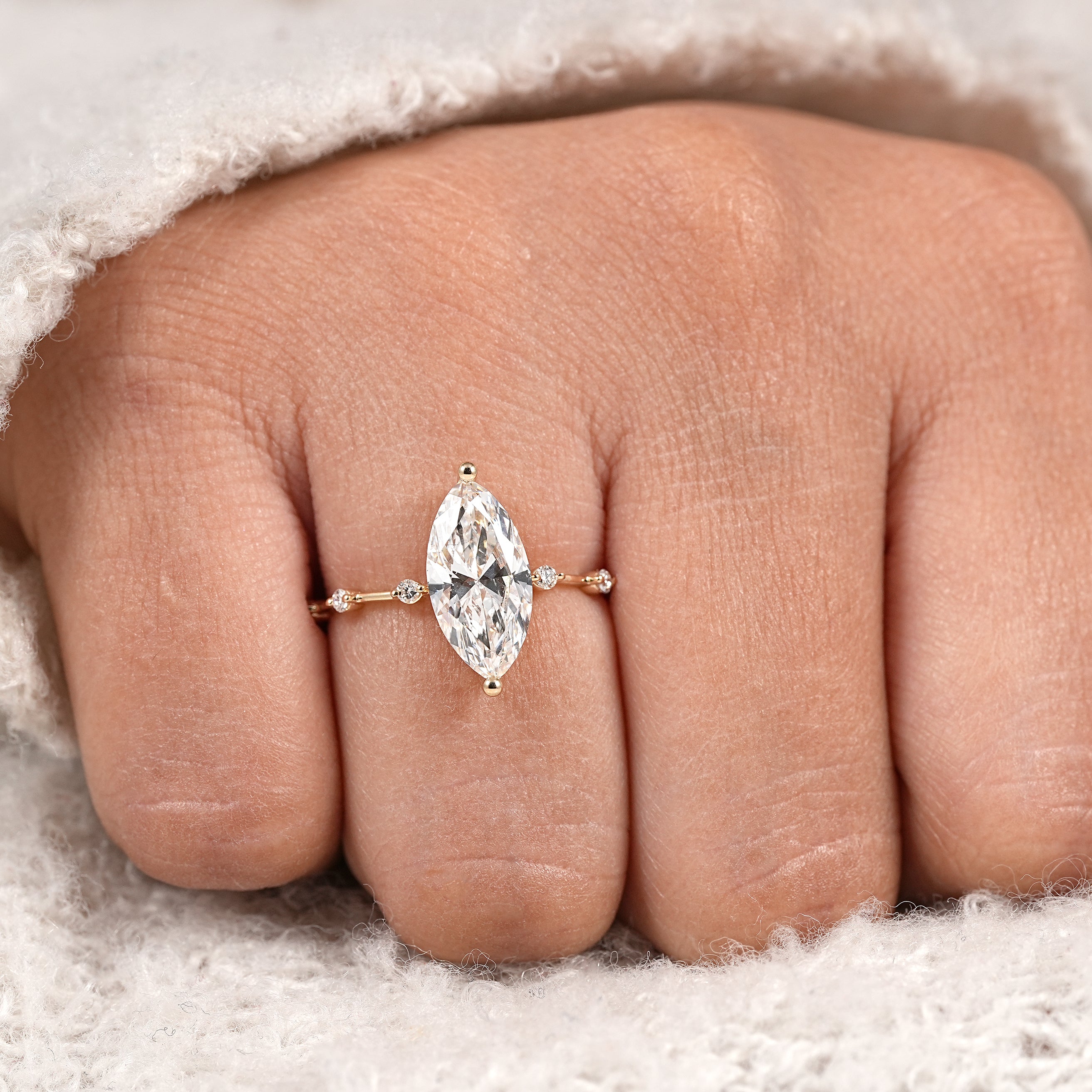 Delicate marquise solitaire ring with round diamond accent band in yellow gold