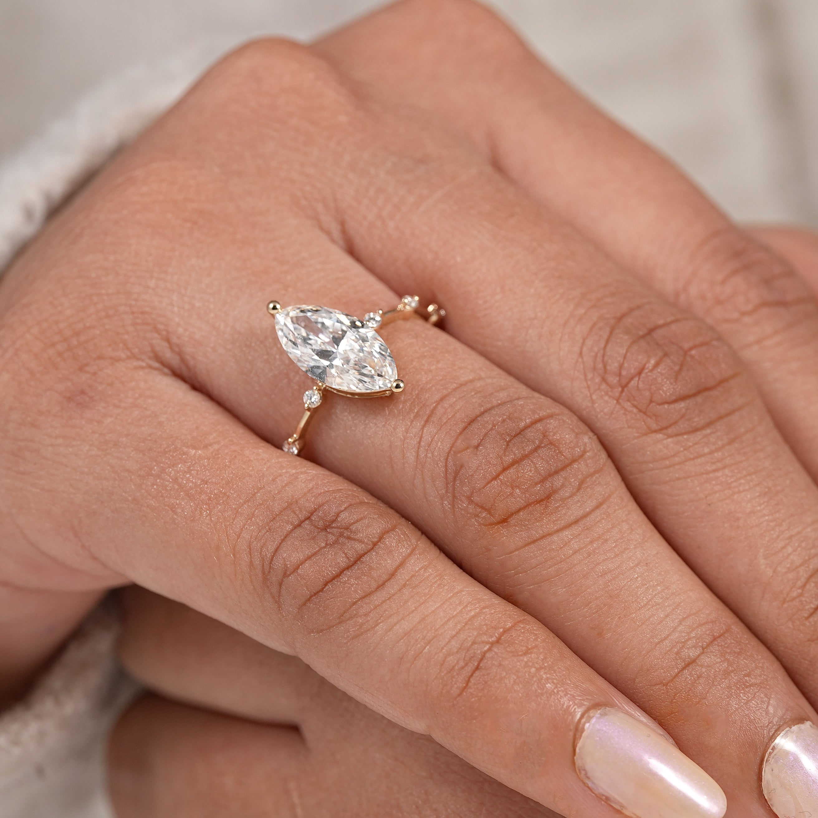 Dainty marquise engagement ring with floating round diamond station setting