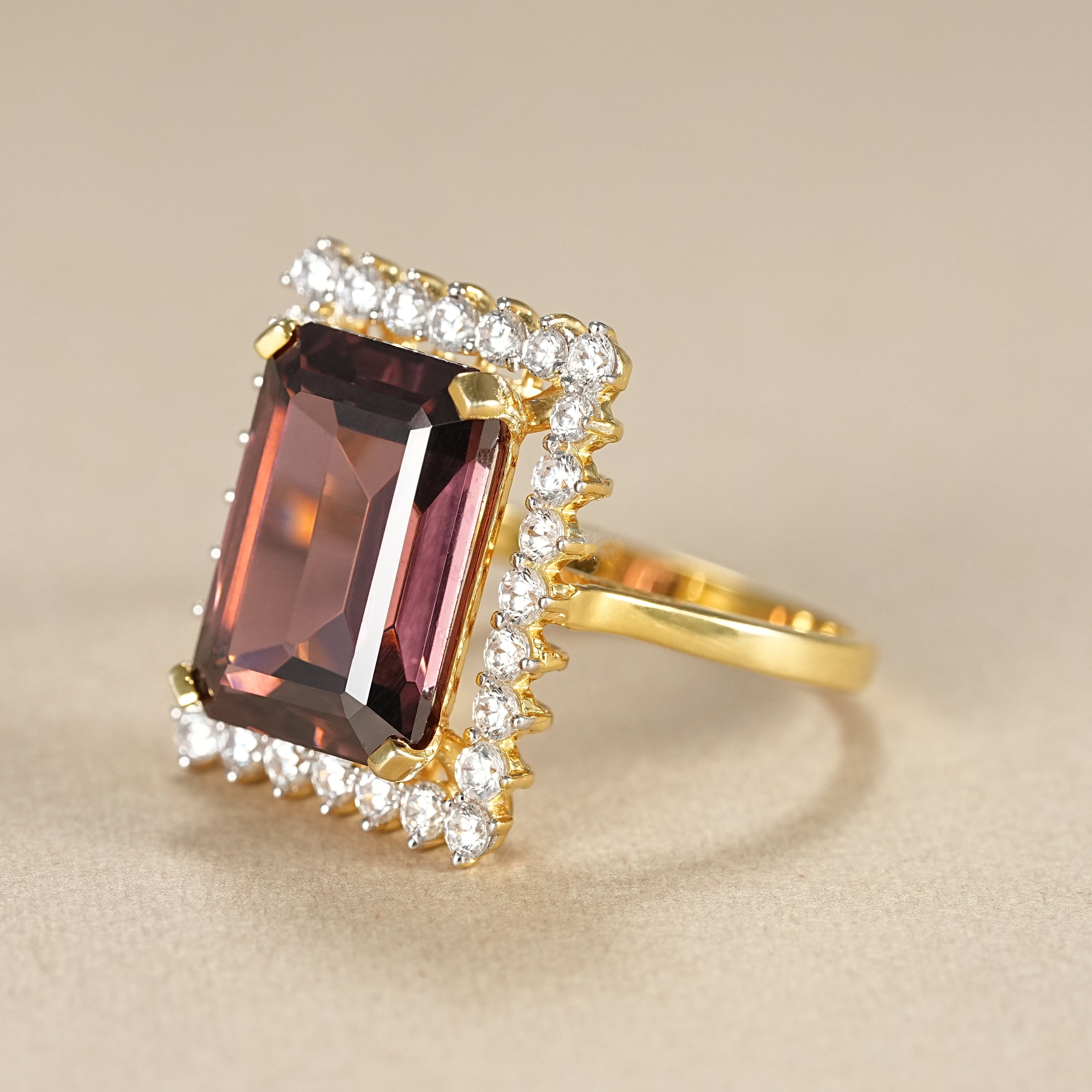 Statement garnet engagement ring with emerald cut center stone and halo diamonds