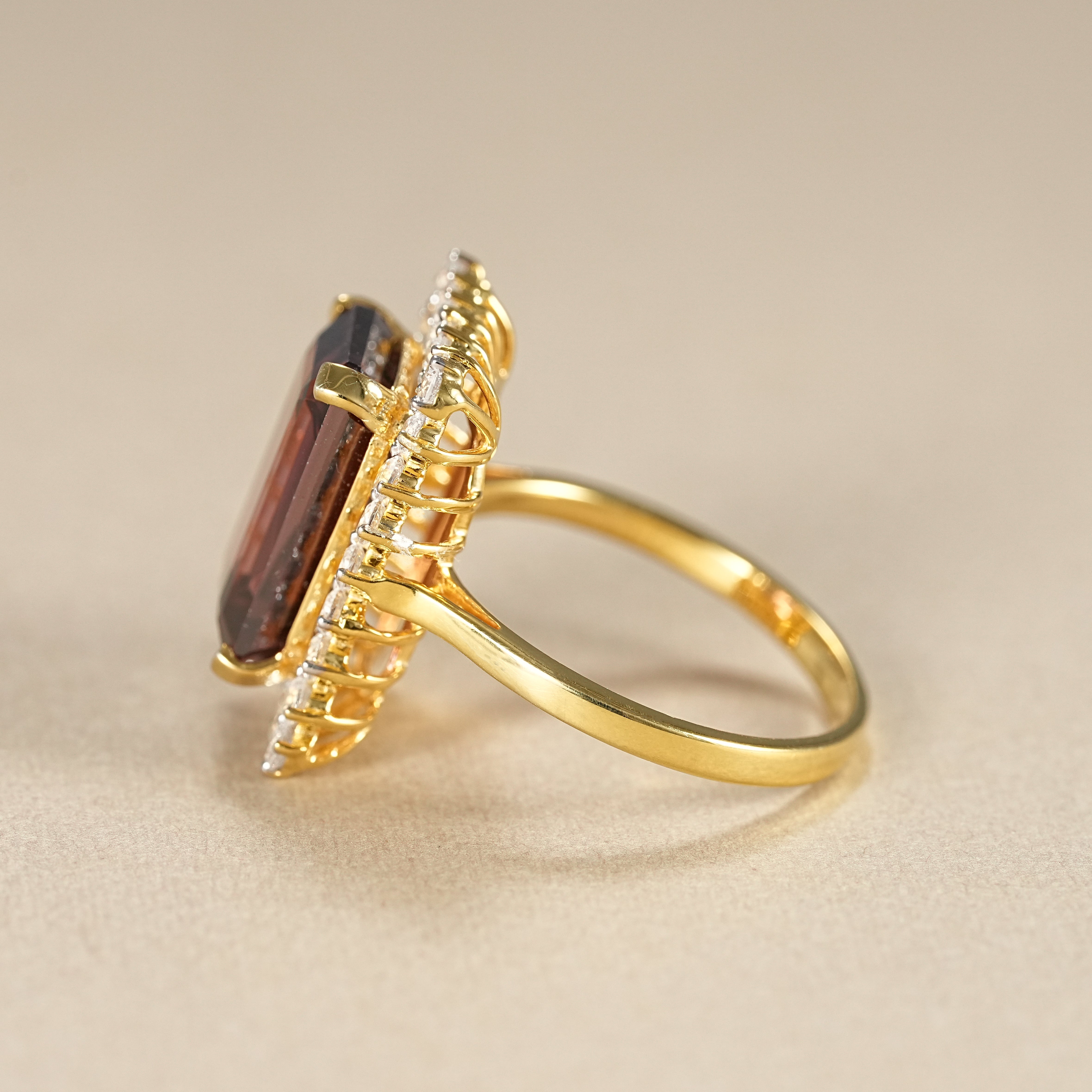 Yellow gold garnet halo ring with emerald cut gemstone and round diamond border