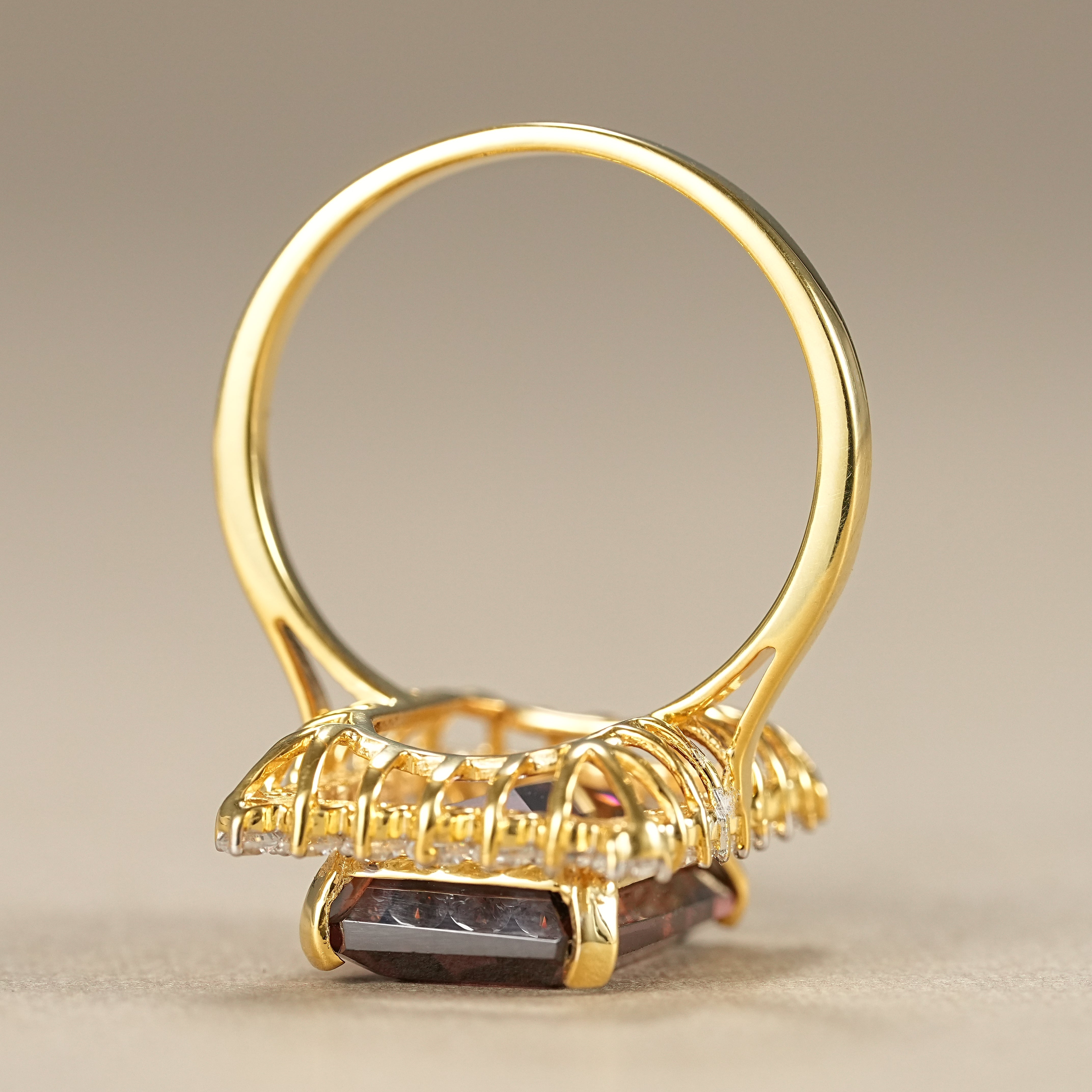 Elegant emerald cut garnet cocktail ring with diamond halo in gold setting